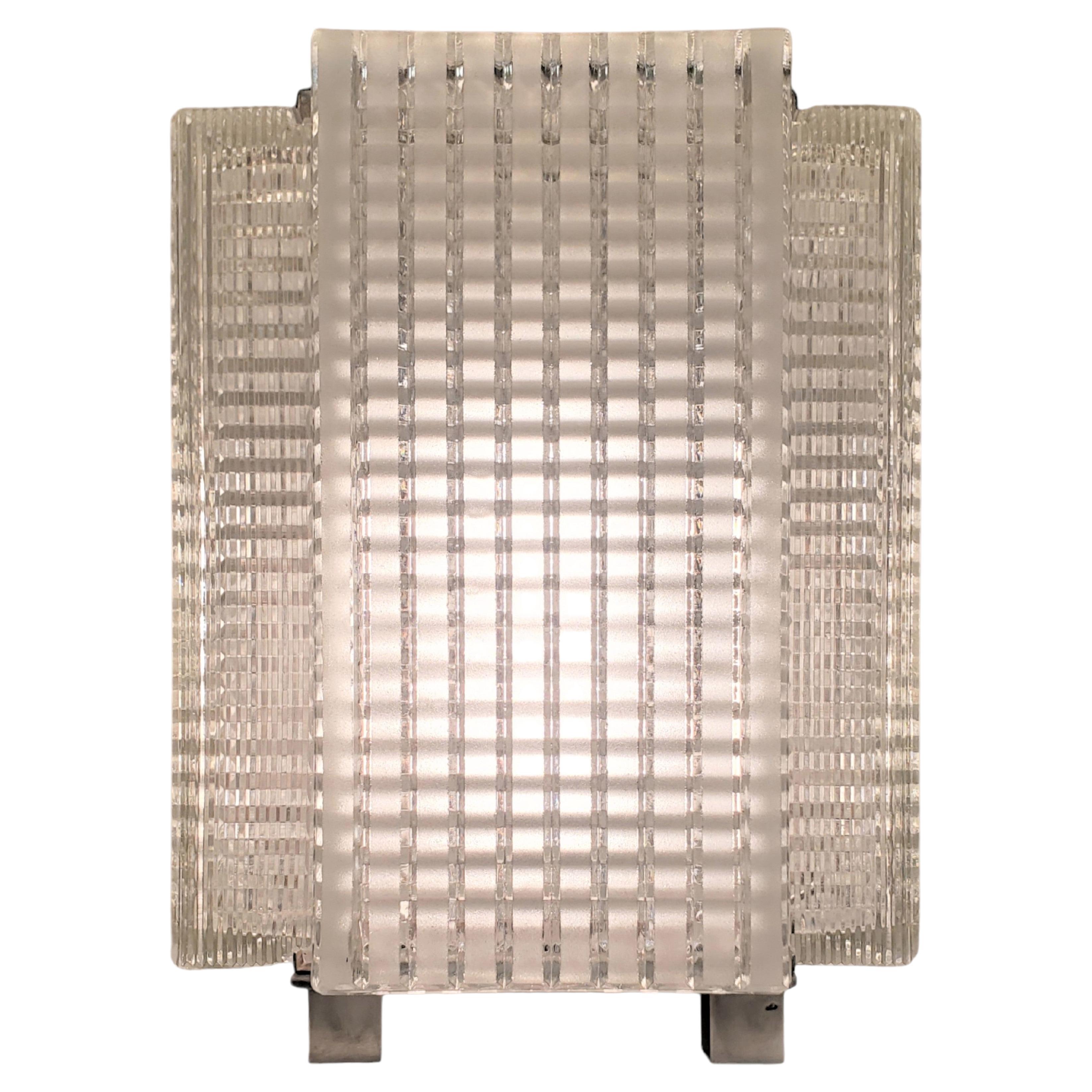 A pair of Midcentury reticulated glass table lamps with nickeled trim.
Four heavily molded art glass panels of rectangular form create this Minimalist glass structure.
Highly architectural in overall form with motif of interlacing lines in a network