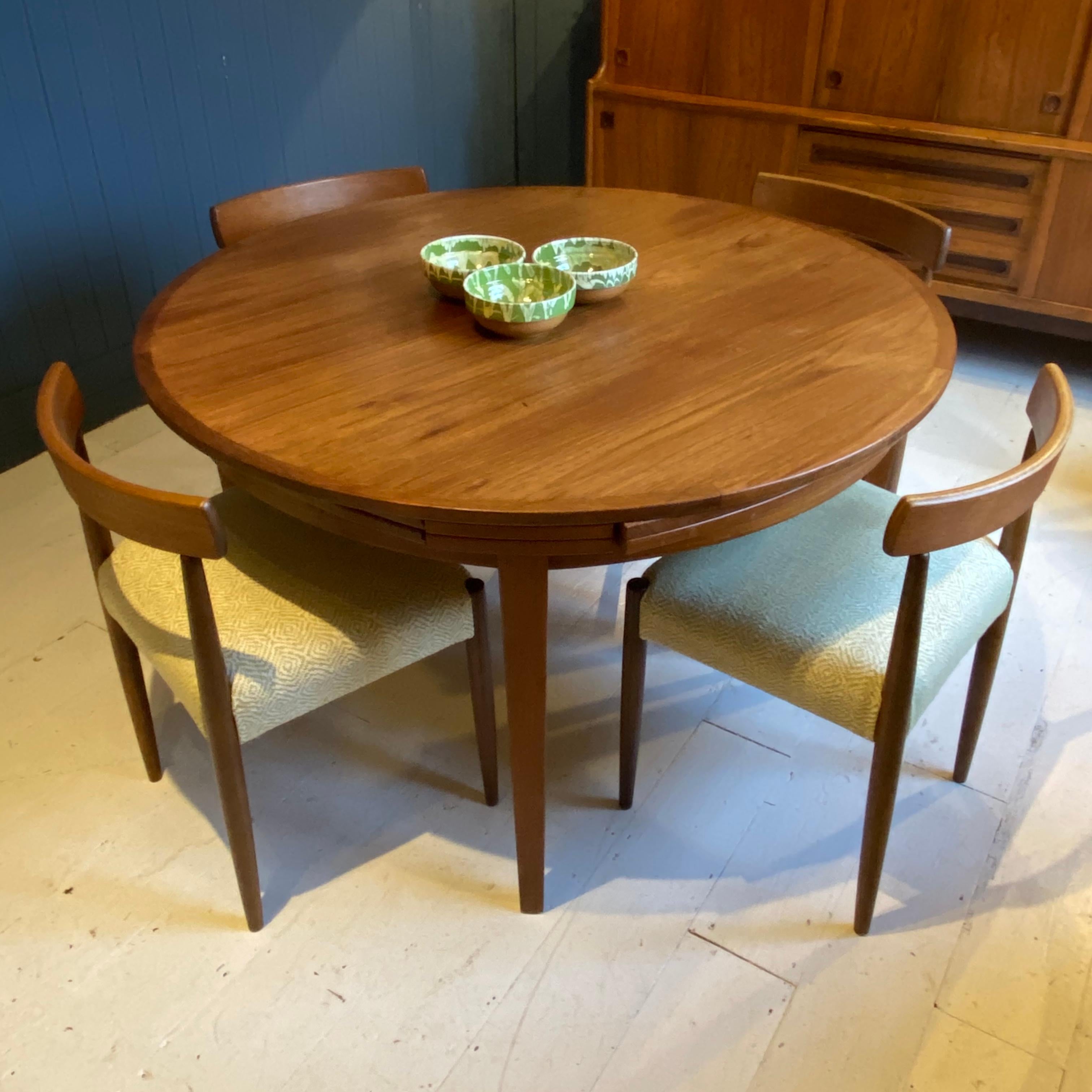 A delightful circular teak extending dining table. The teak flip-flap table was manufactured by Dyrlund, Denmark. Danish design at its best. The table has four internal slides that pull out / pull-out and then flip over clockwise to extend the