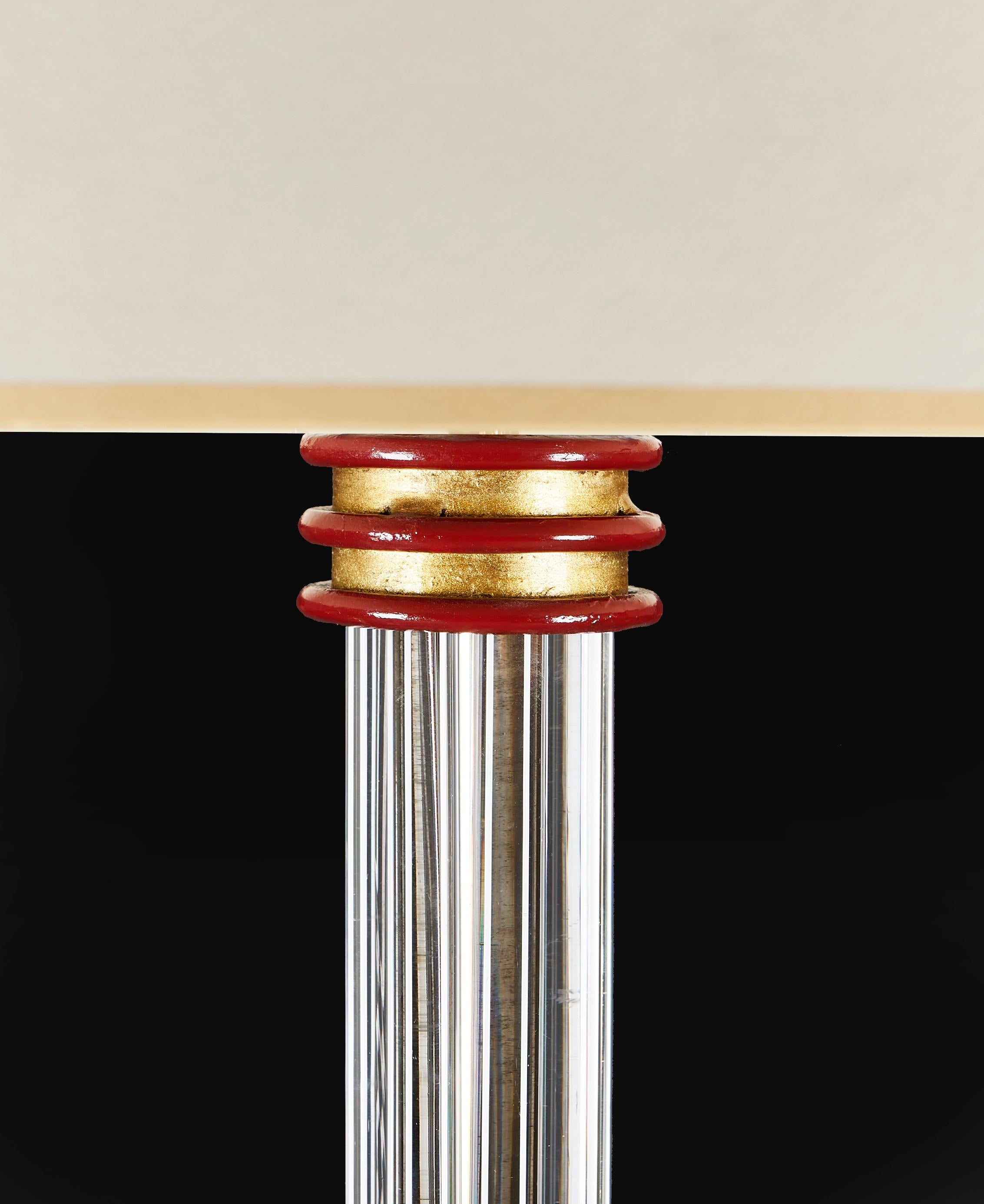 Un inhabituel lampadaire en verre du milieu du siècle avec une base tripode peinte, la tige centrale en verre étant soutenue par des colliers cylindriques peints et dorés à la manière de Jules Leleu.

Veuillez noter :

Abat-jour non compris. Lampe