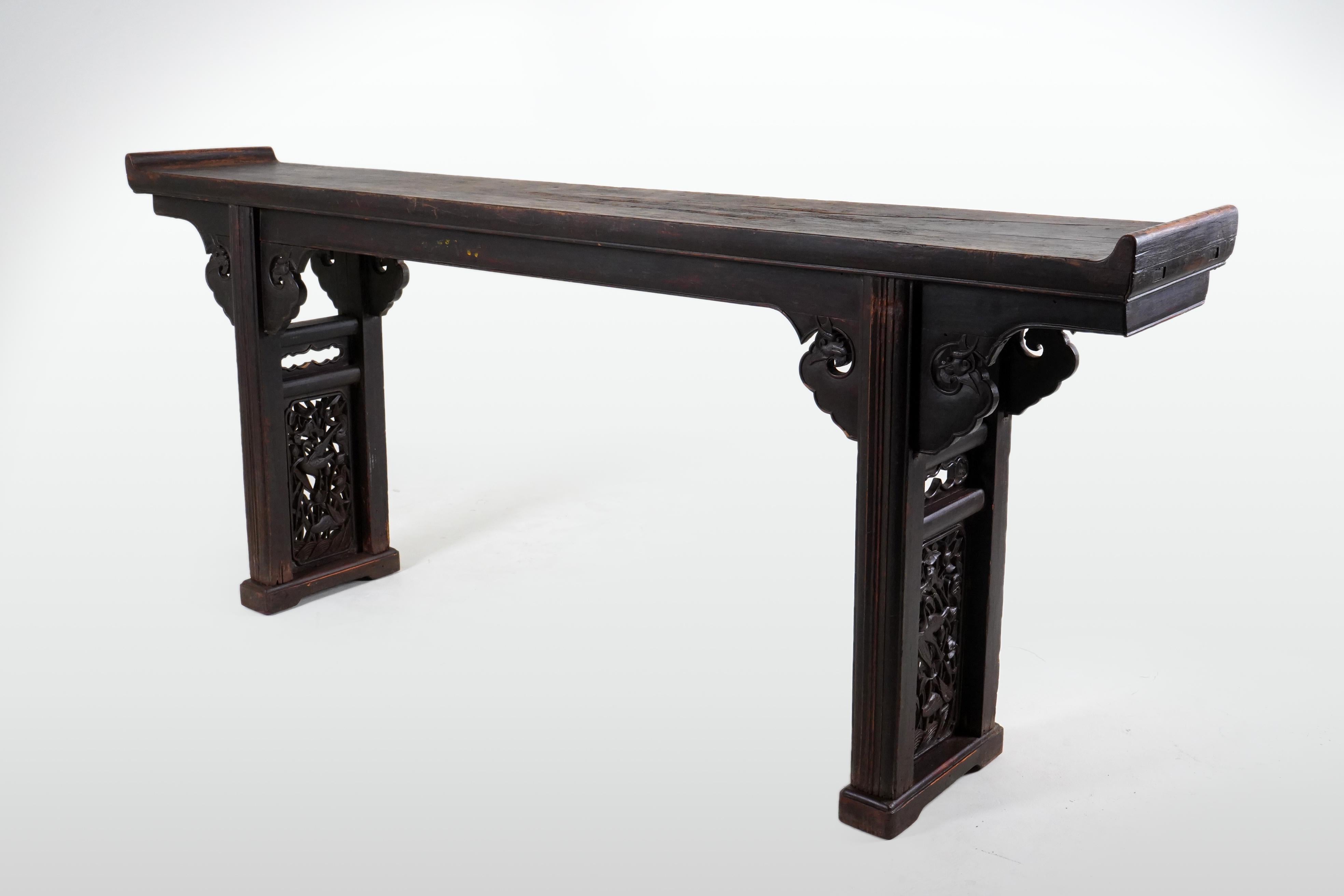 This long and graceful Chinese altar table features an oxblood patina that has darkened with age. Oxblood is one of the three traditional Chinese lacquers, including red and black, both of which are fully opaque. Oxblood is semi-translucent and