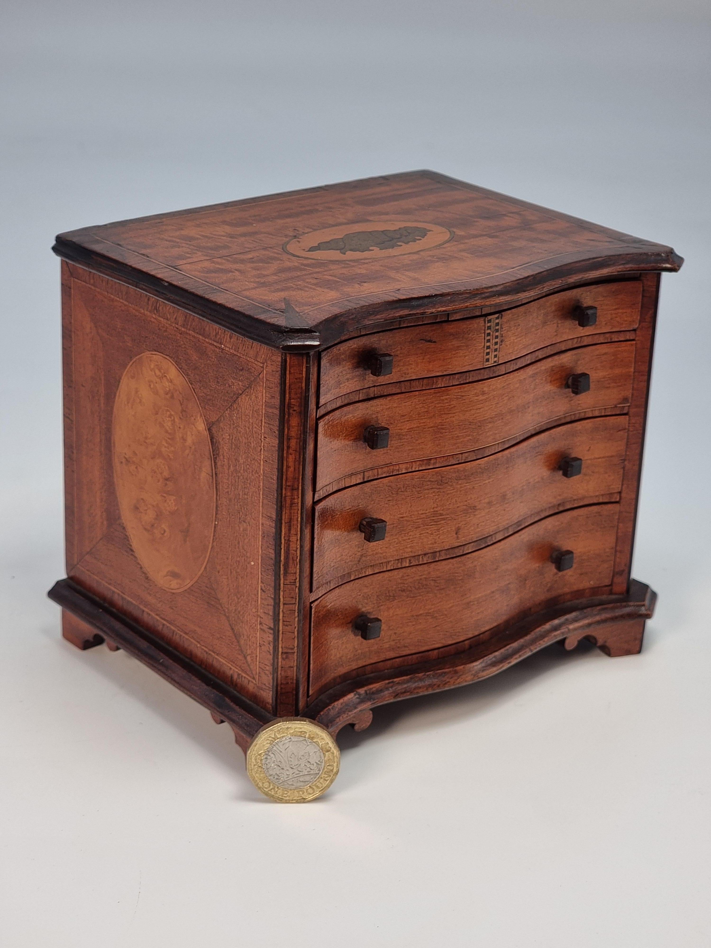 This exceptionally fine quality piece of English miniature cabinet making is a real gem dating to 1907 and fully signed and dated in the top draw in pencil, A F Lloyd, Bideford 1907.

This fine piece has been accurately made to scale copying a very