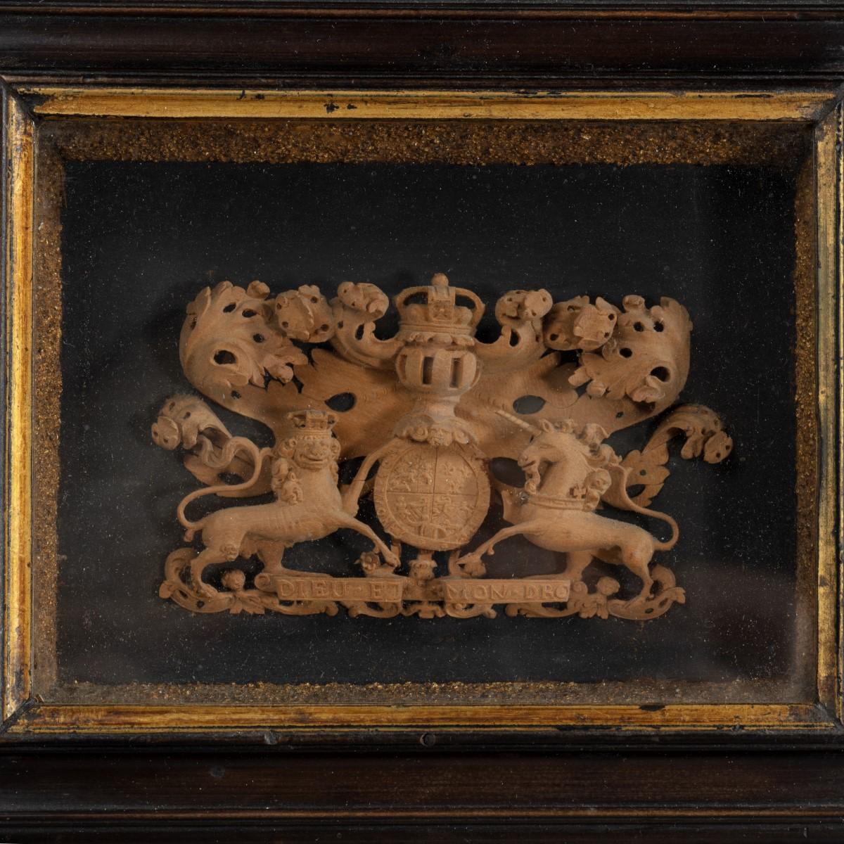 A miniature coat of arms for the Kingdom of Great Britain, 1714-1800, carved for the stern of a ship’s model from limewood or boxwood, in a deep, lined frame with a gilt border.  English, circa 1760.