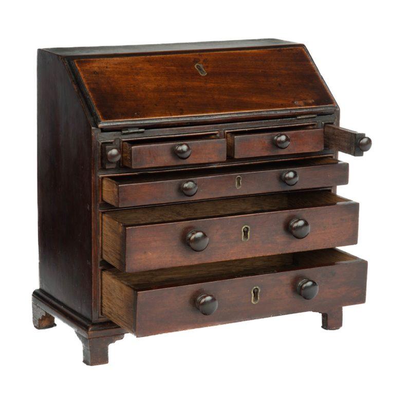 A miniature George III mahogany bureau, of rectangular form with a fall front and fitted secretaire interior above two short and three graduated long drawers, raised on bracket feet.  English, late 18th century.

