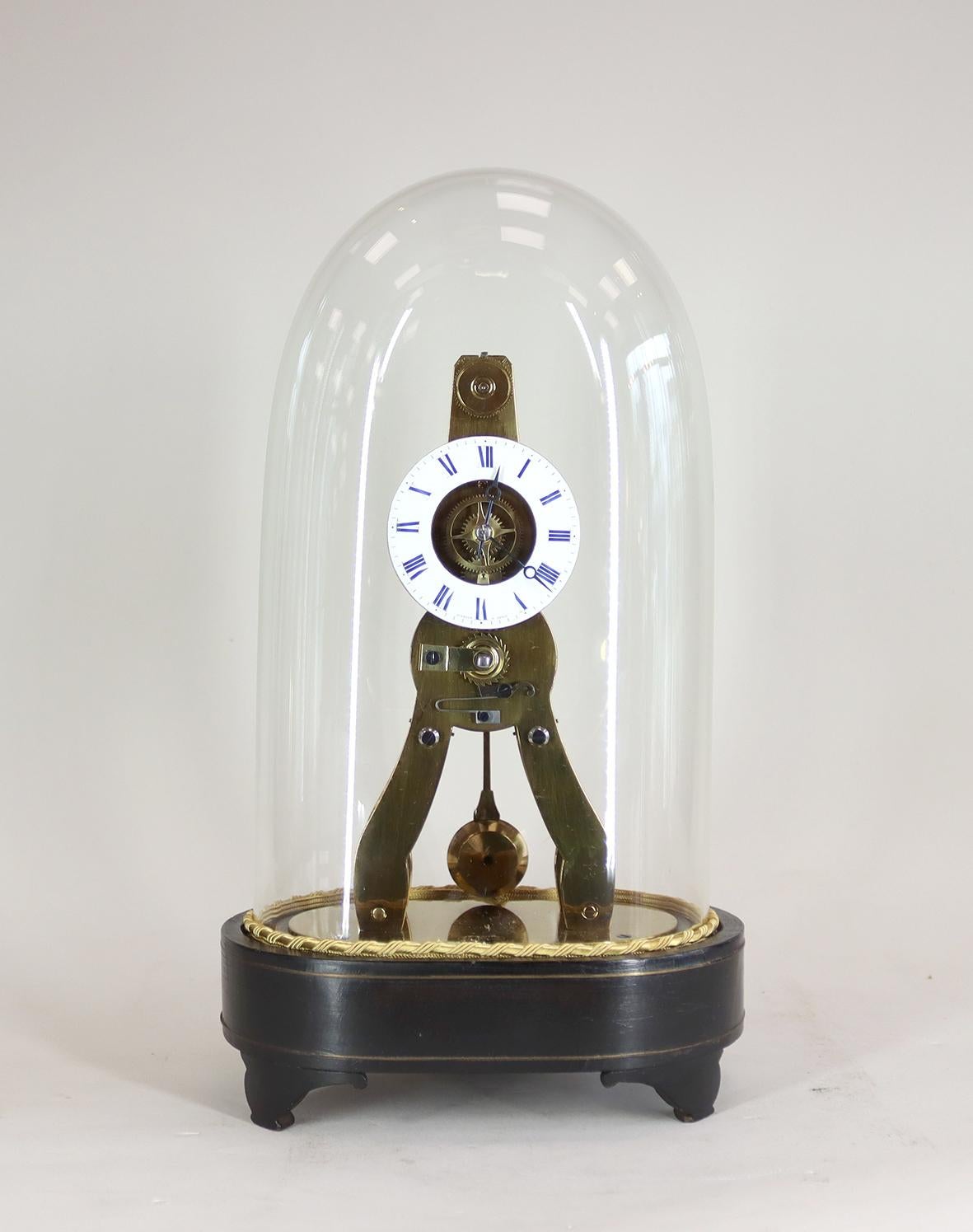 A miniature French skeleton clock with silk suspension and eight day movement, dating from the mid 19th century, with original glass dome on an ebonised and brass inlayed base with enamel dial.

This clock was made by Victor Athanase Pierret whose