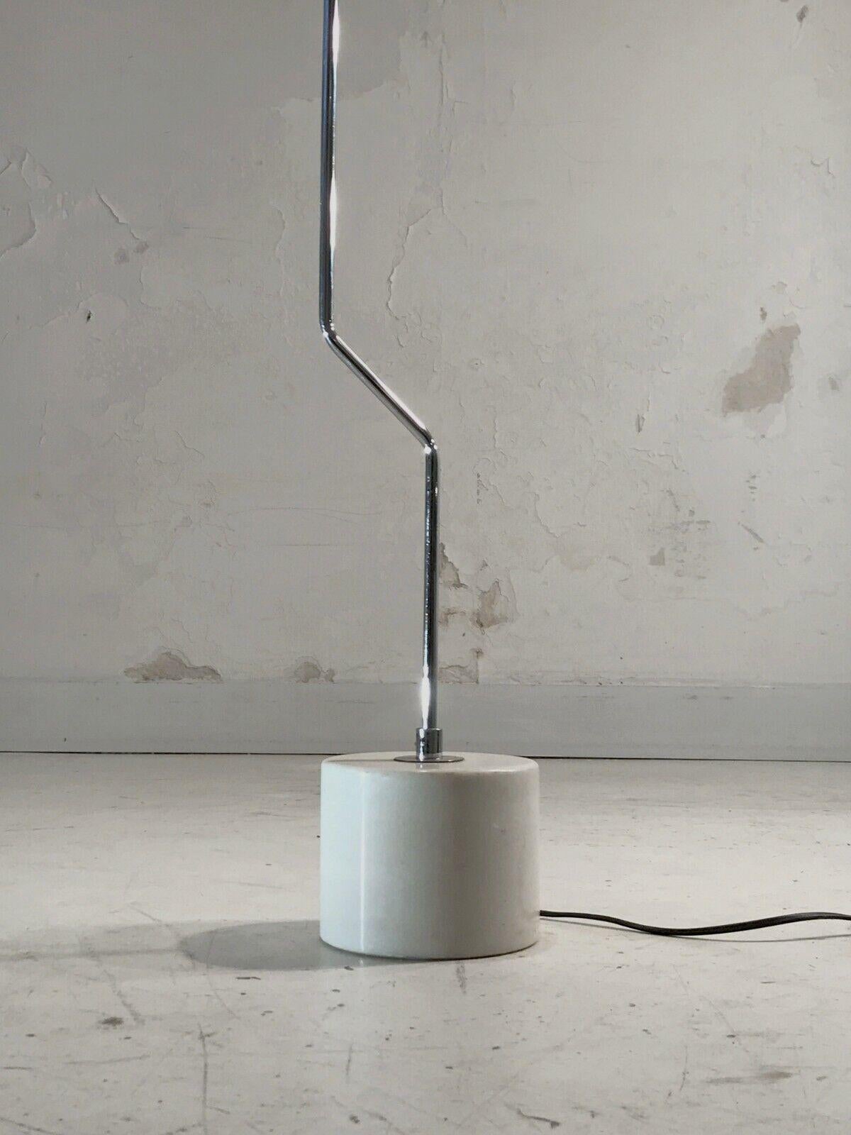 A rare minimalist floor lamp, with a cylindrical base in white Carrare massive marble, with a vertical metallic axis displaced on diagonal at the bottom, with a black lacquered metallic structure made for a Cornalux light-bulb. Simple and elegant.