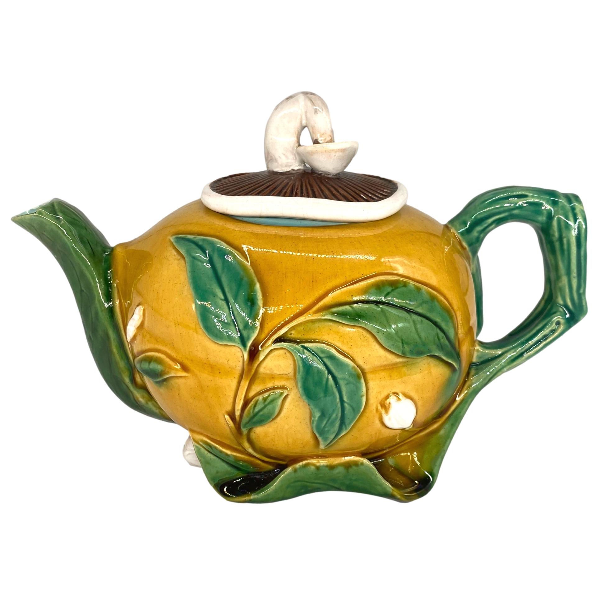 A Minton Majolica Novelty Teapot formed as a yellow-glazed gourd with blossoms on raised leaves and blossom, surmounted by a lid naturalistically molded and glazed as a mushroom, the reverse with impressed marks 'MINTON' and date code for 1861. 