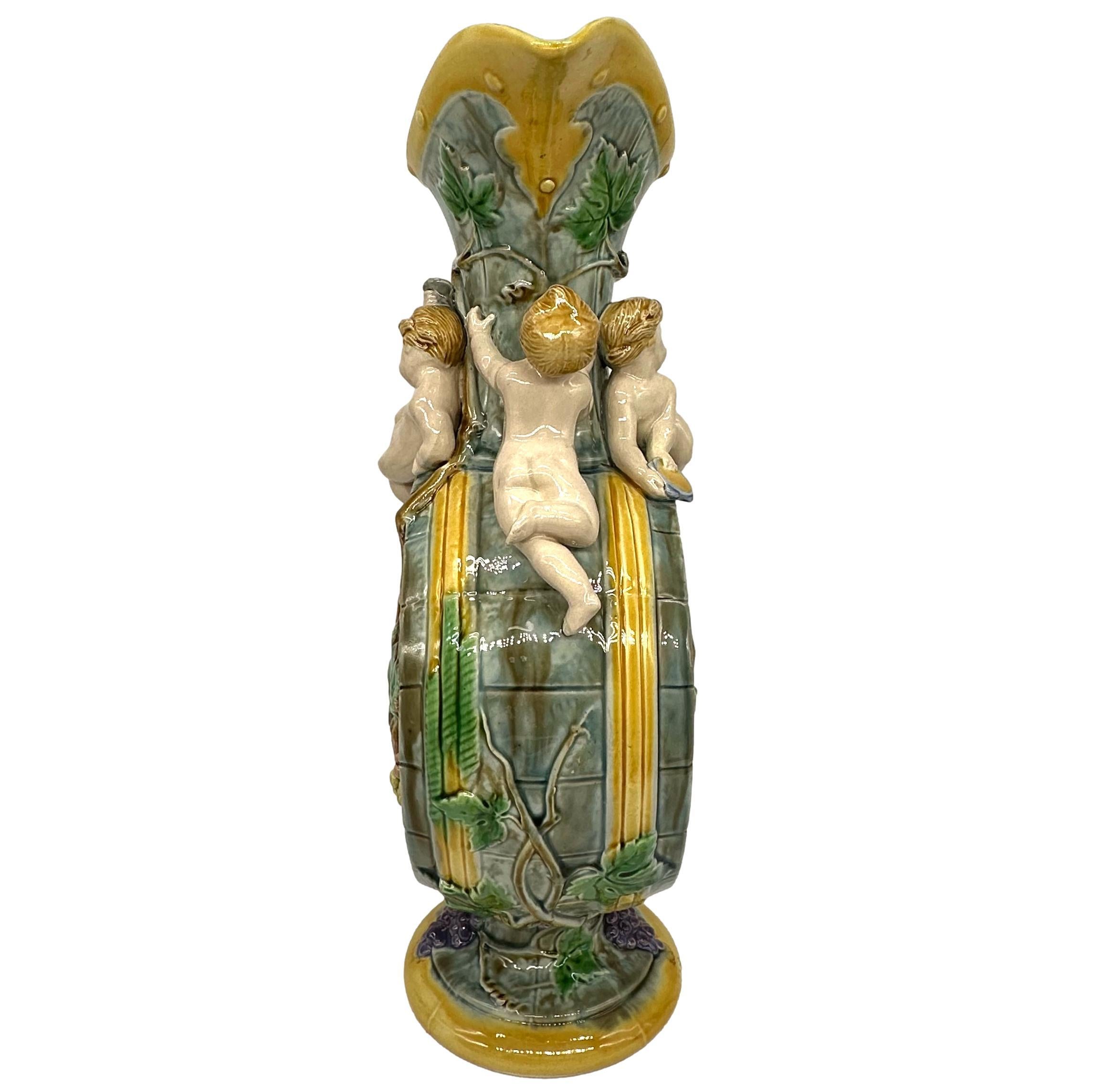 Aiguière à vin en majolique de Minton Design/One par Hugue Protât (actif 1835-90),  Anglais, vers 1875. 1875, le corps moulé comme un tonneau de vin avec des vignes au centre, surmonté de quatre chérubins bacchanales, avec un bec verseur en forme et