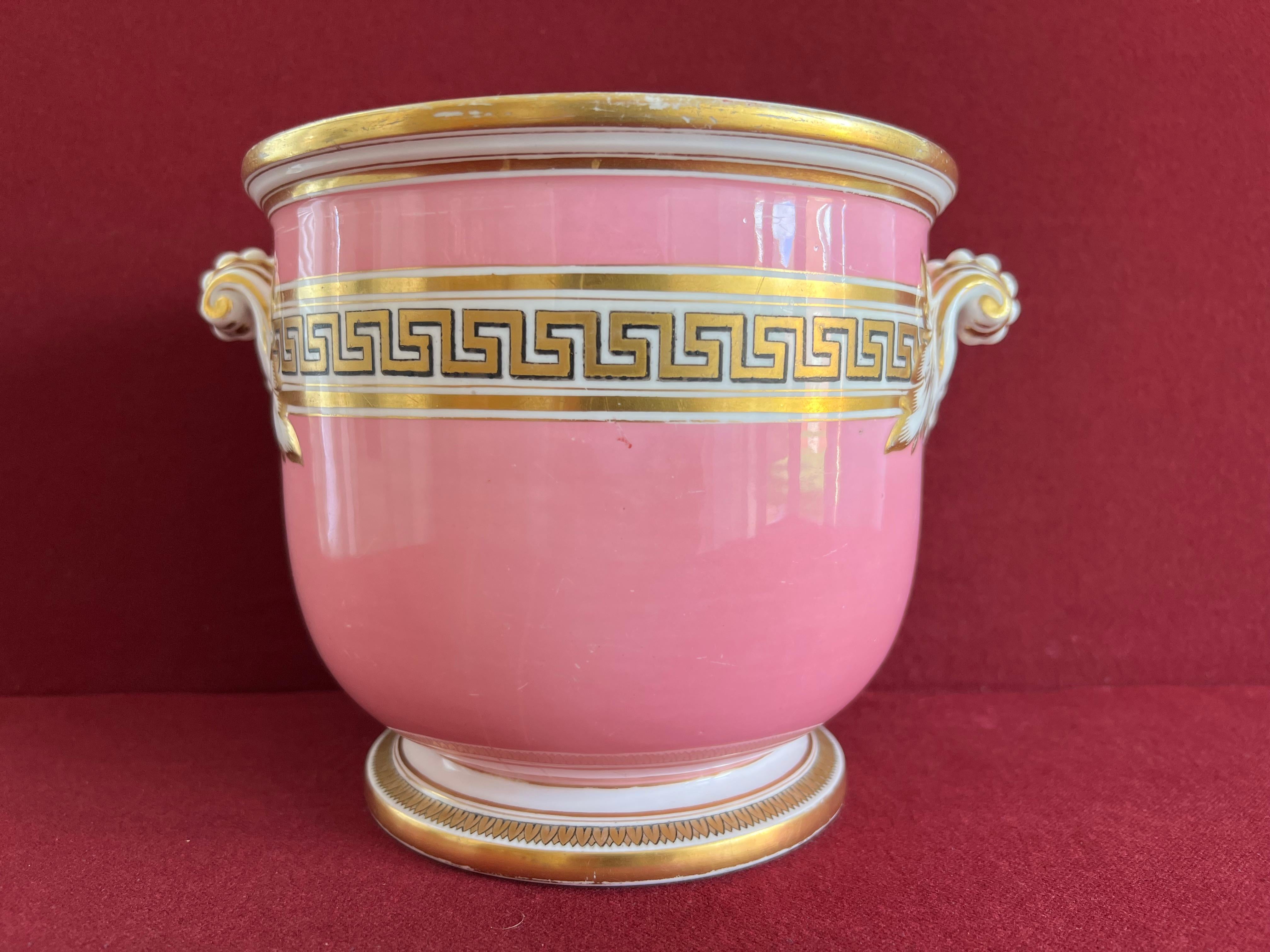 A fine Victorian Minton Porcelain Jardiniere circa 1850. Finely decorated with a pink ground and a band of Greek-key decoration in gold.
Each side of the Jardiniere with fixed scroll handles with white beading and acanthus leave terminals.