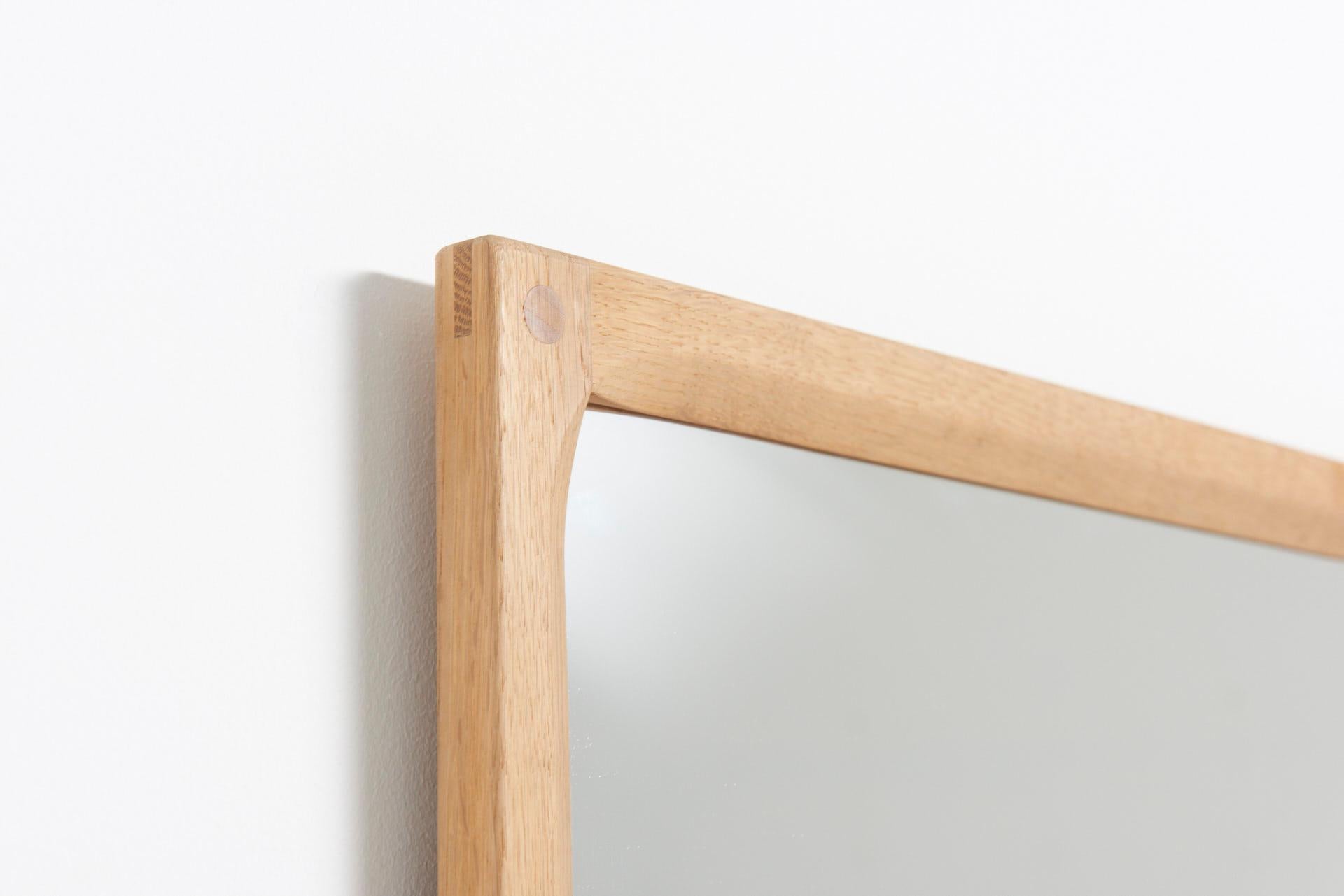 A large mirror with a frame in soap treated oak. Designed by Kai Kristiansen in 1960, and made by Aksel Kjersgaard in Denmark.