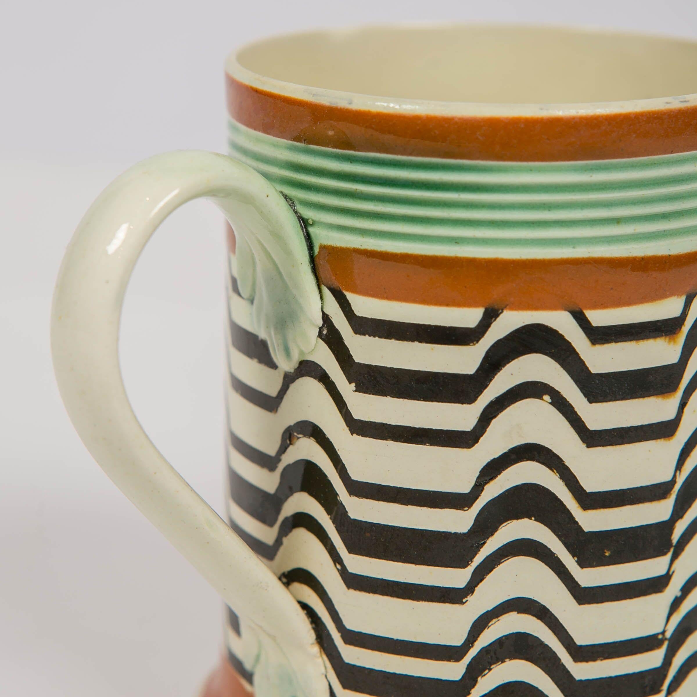 Why We Love It:
The design is hypnotic.
A Mochaware mug made by J.& R Clews at the Cobridge Factory, England, circa 1820. The design is achieved by the use of a crown cam tool to create irregular patterns like the black and white pattern seen on