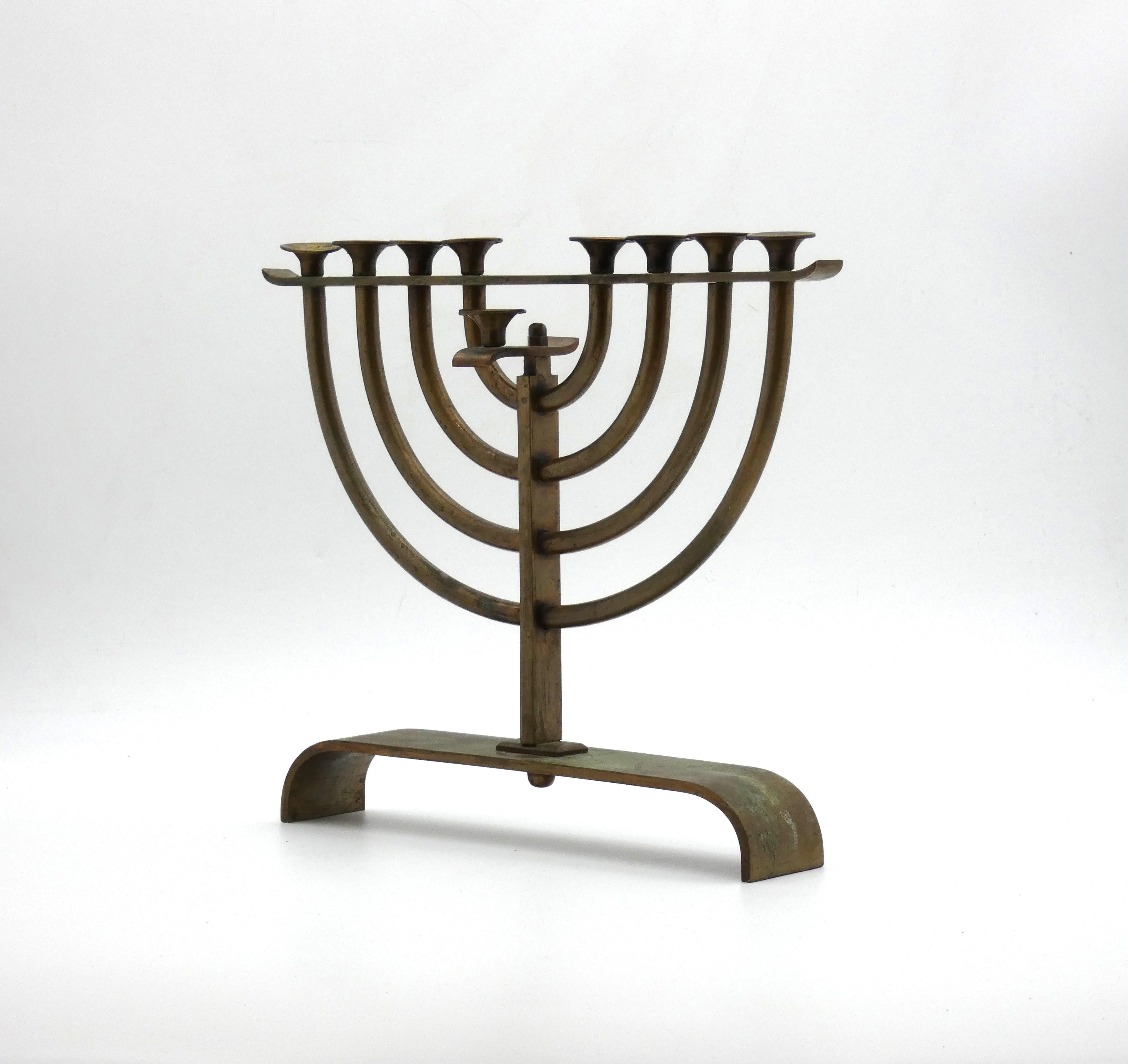 This modern designed menorah was made at the start of the modern era in Israel in the 1930's

Menorah rests on a curved C-shaped base and has eight connecting pipe-shaped stems branching out and connected to the center stem. 

Center stem is