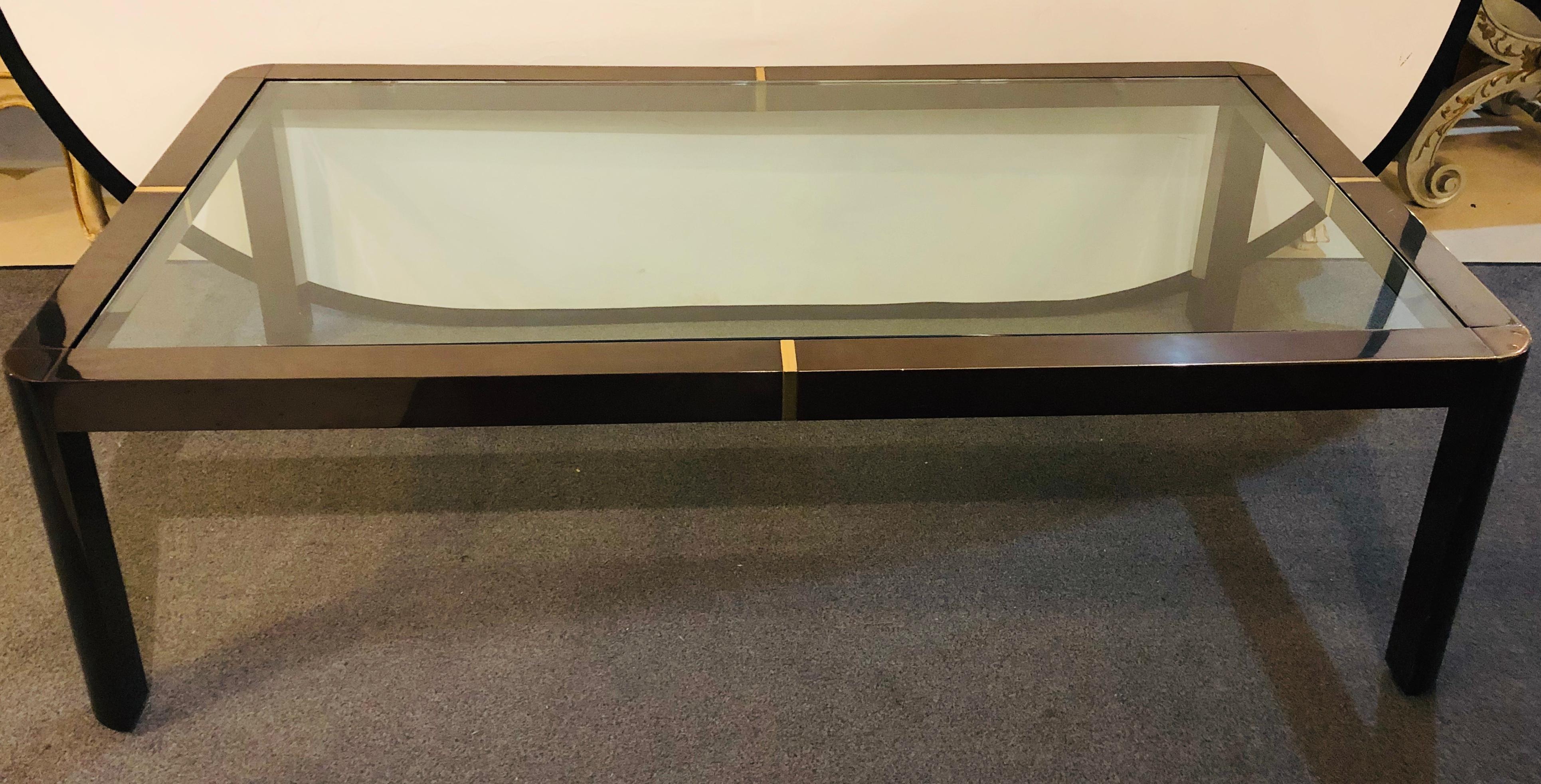 Une table basse/café moderne. Laiton, métal et verre. Cette belle table basse en métal de style Hollywood Regency a des supports en verre cachés sur un cadre en laiton et en métal.

  