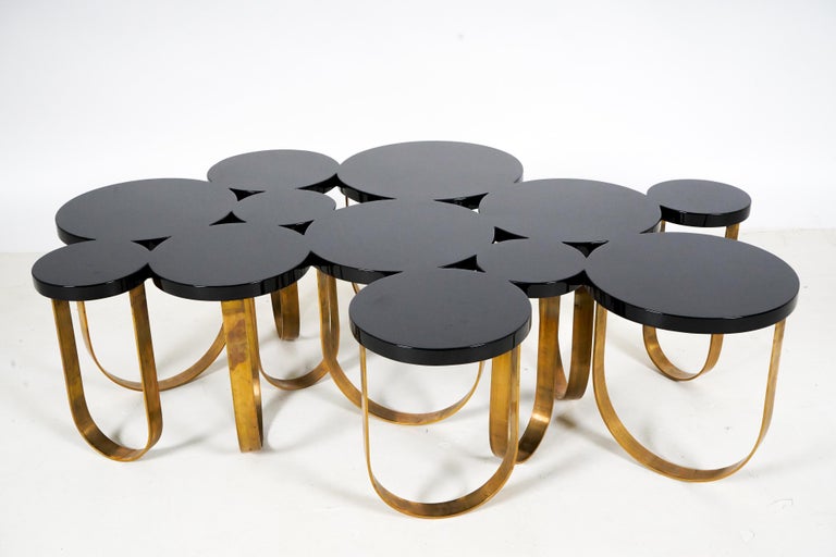 A Modern Coffee table With Solid Brass Legs and a Black Lacquer Top For