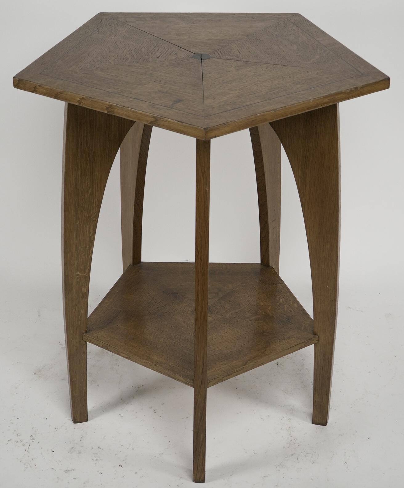A modern craftsman made Arts and Crafts oak pentagonal centre table with a triangular segmented top inlaid with Walnut to the centre, with five arched legs uniting the lower shelf.
