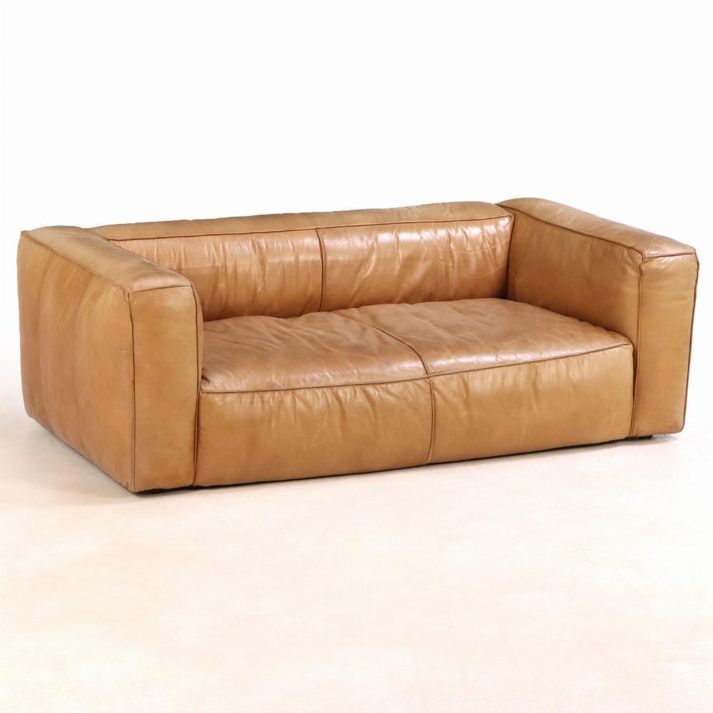 This striking French leather sofa makes a lasting impression with its clean, minimalist design. Featuring a straight low back and wide, square arms, it beautifully fuses mid-century modern sensibility with vintage charm. Upholstered in rich, supple