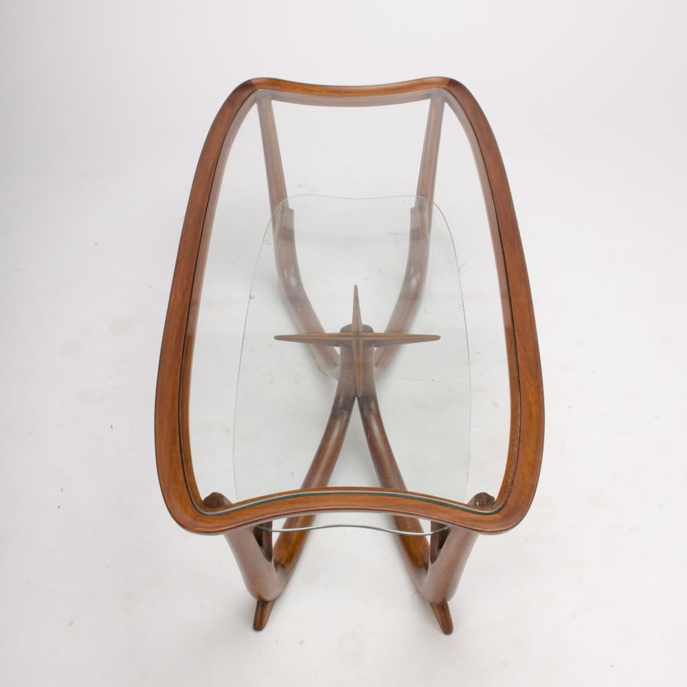 A superb modern Italian organic mahogany and glass two-tier coffee table. The inset glass top rests in a mahogany frame supported by biomorphic legs, Circa 1950.