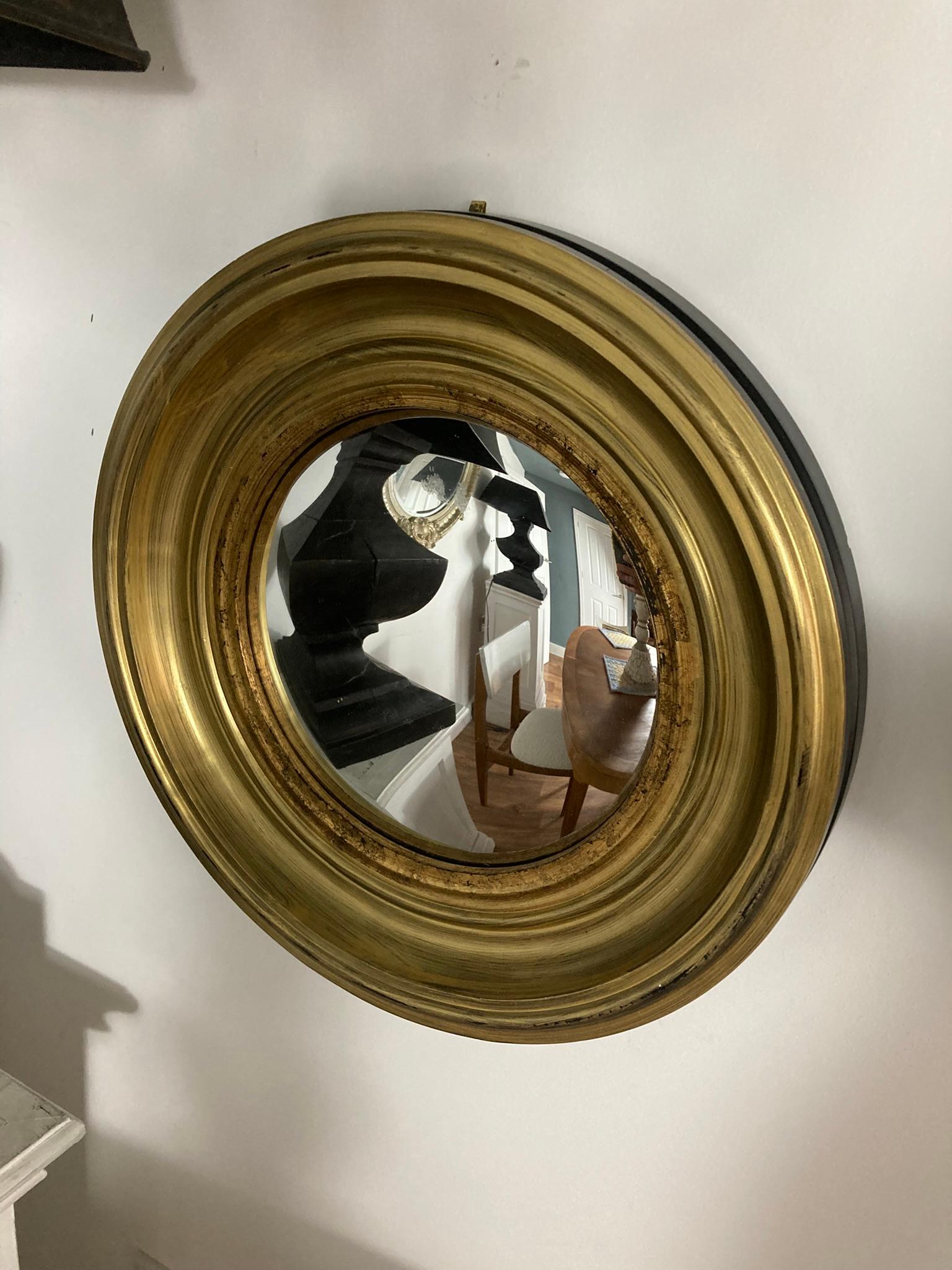 A Modern Gold Circular Convex Mirror with ebonsied Rim. The elegant gold frame adds a touch of luxury, while the sleek black rim offers a modern contrast, making it perfect for any interior style. Ideal for enhancing natural light and creating the