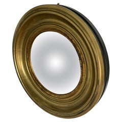 A Modern Regency Style Gold Circular Convex Mirror with ebonsied Rim