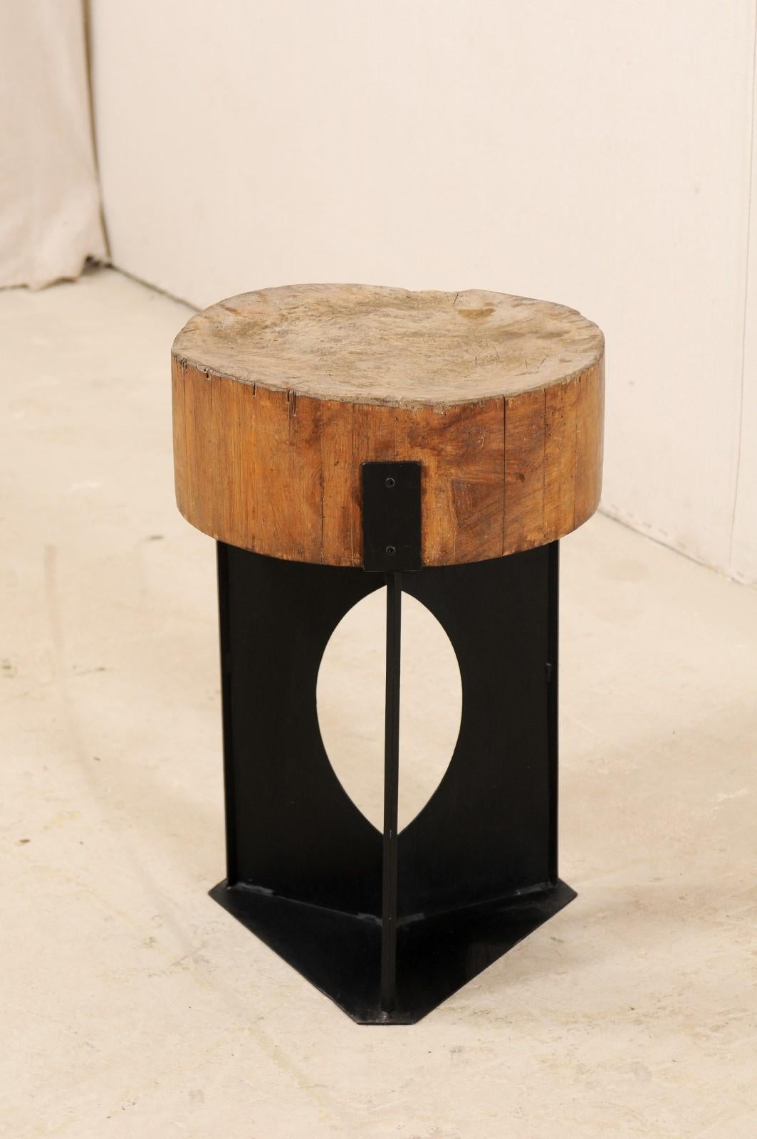 This modern-designed side table has been custom fashioned with a European 19th century chopping block top mounted onto a contemporary iron base. This unique and one-of-a-kind piece has been created with an intriguing mix of rustic and modern