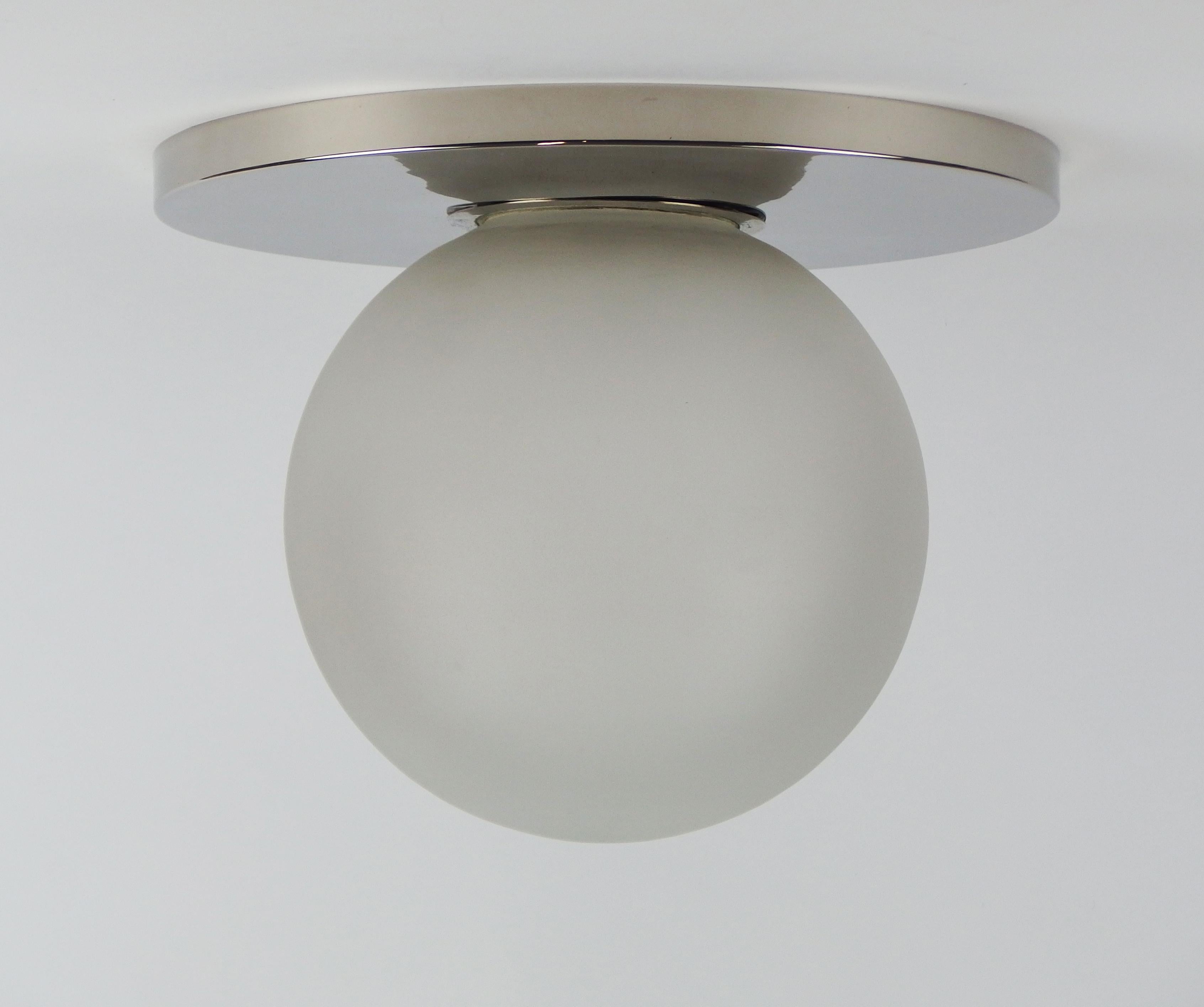 A modernist Art Deco flush mount in the style of Bauhaus with a thick frosted glass sphere mounted on a nickel-plated structure.
Measures: Sphere diameter 9.44 in.