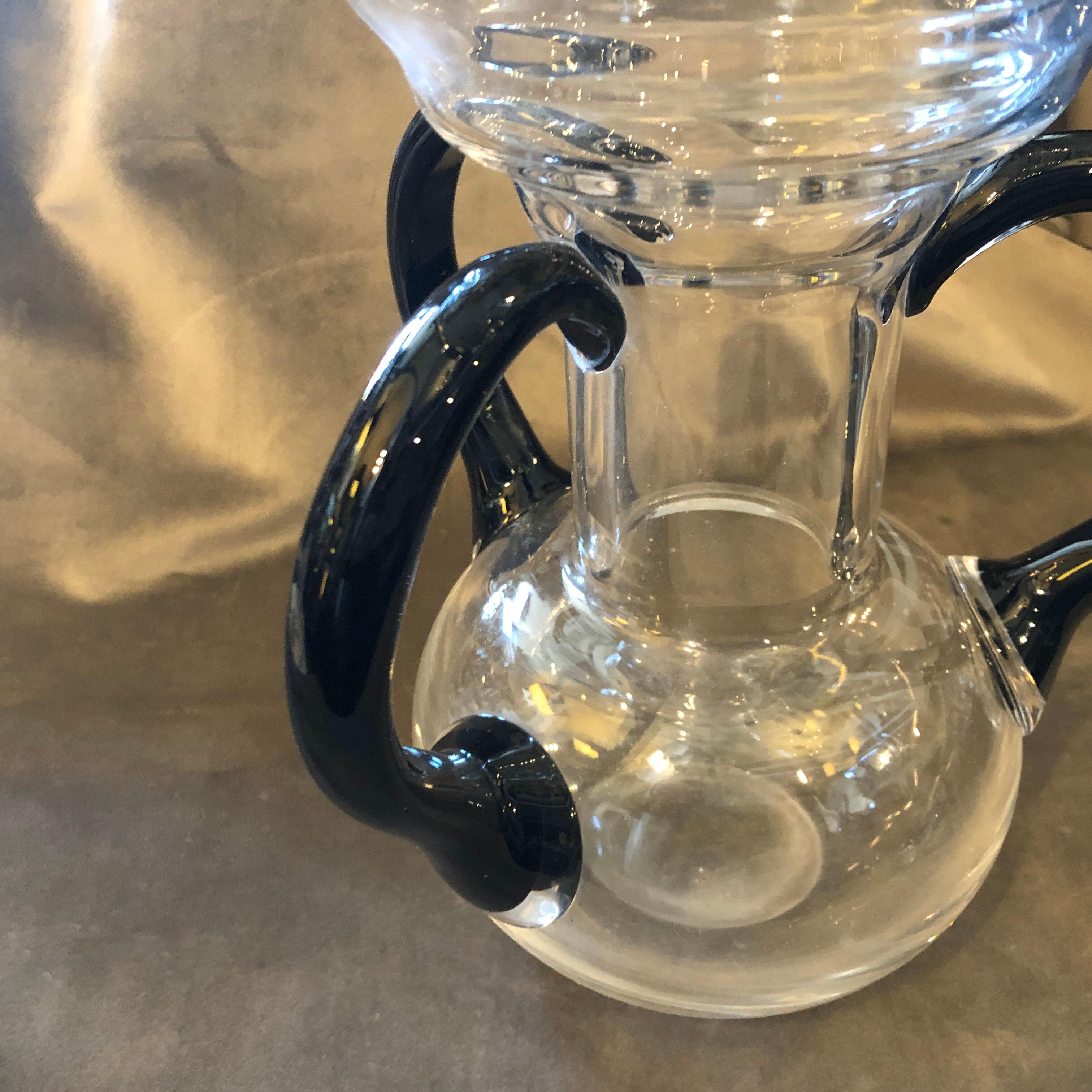 A three handles glass vase made In Italy in the 1970s, good conditions overall. the three black handles on the transparent body makes it a masterpiece of italian glasses of the Eighties