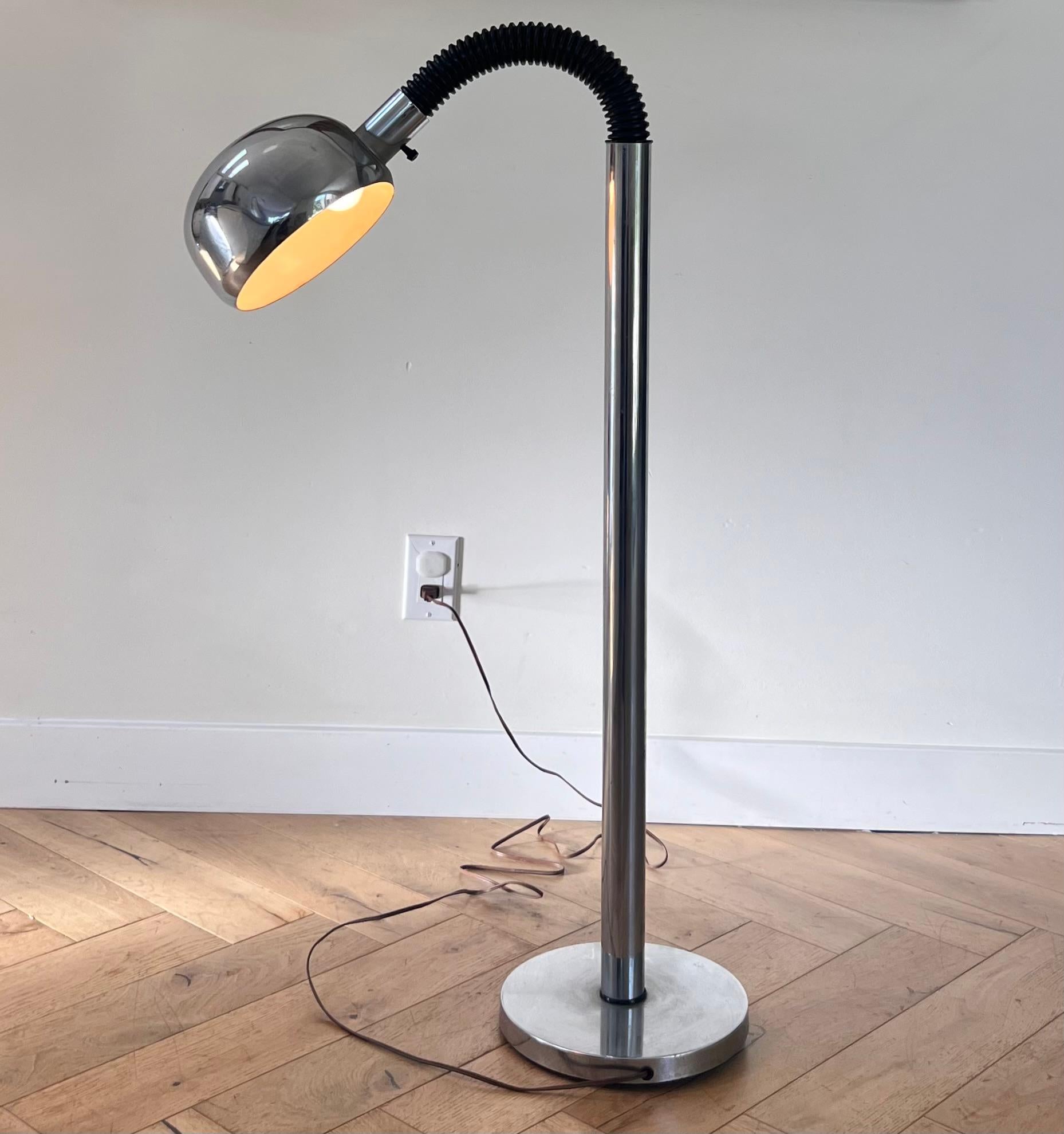 A mid century modern chrome and rubber gooseneck floor lamp, circa 1970. Potentially attributed to Robert Sonneman, telling by the thick chrome, the bulb shade, and the veering toward the postmodern in form. A standard light bulb screws in just