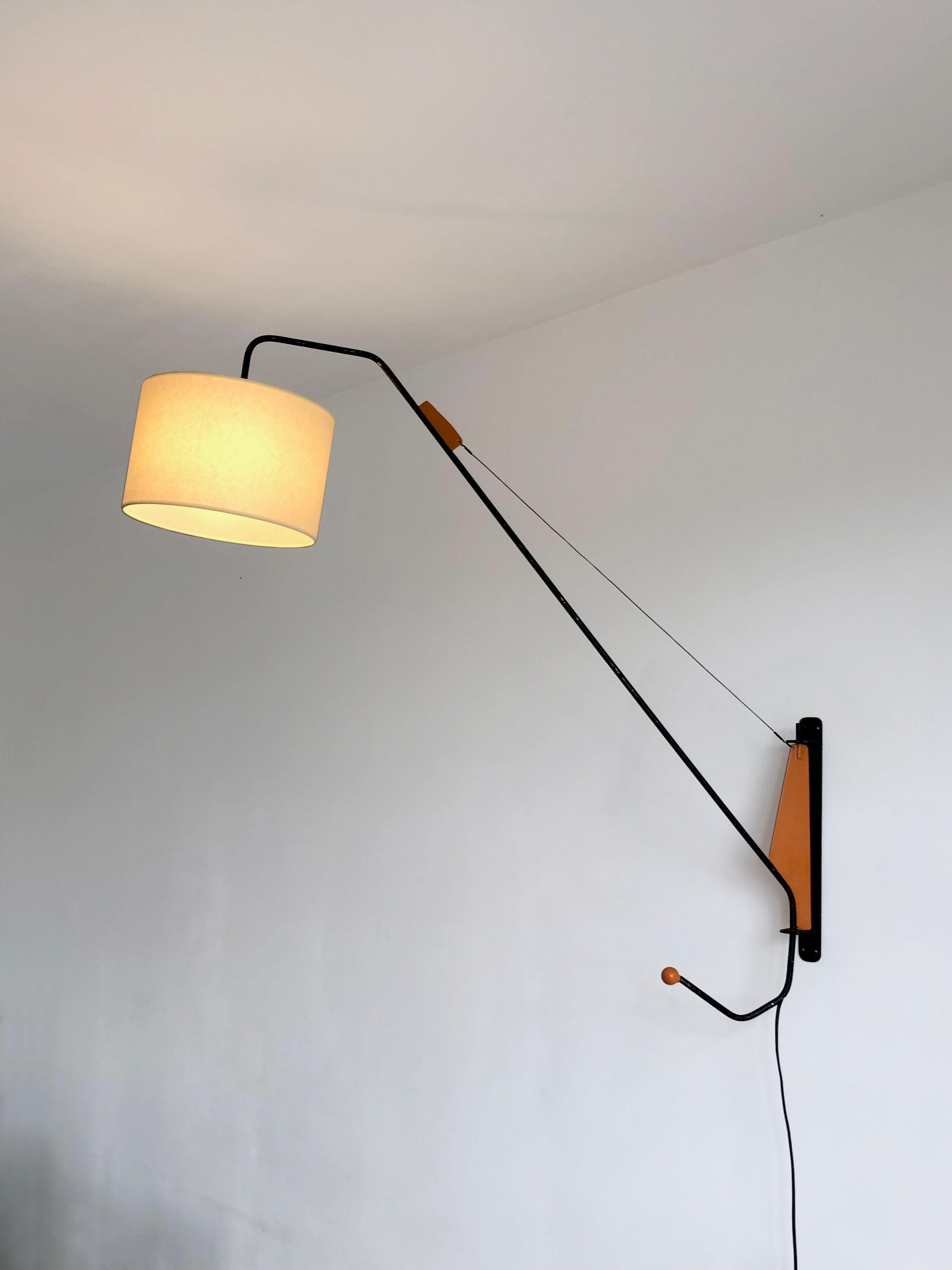 Suspensión mural con brazo regulable, Modernista, años 50, Shabby-Chic, base de metal lacado negro, brazo regulable de metal plegado lacado negro, con acabados naranjas, sostenido por un cable metálico, gran aplique muy gráfico inspirado libremente