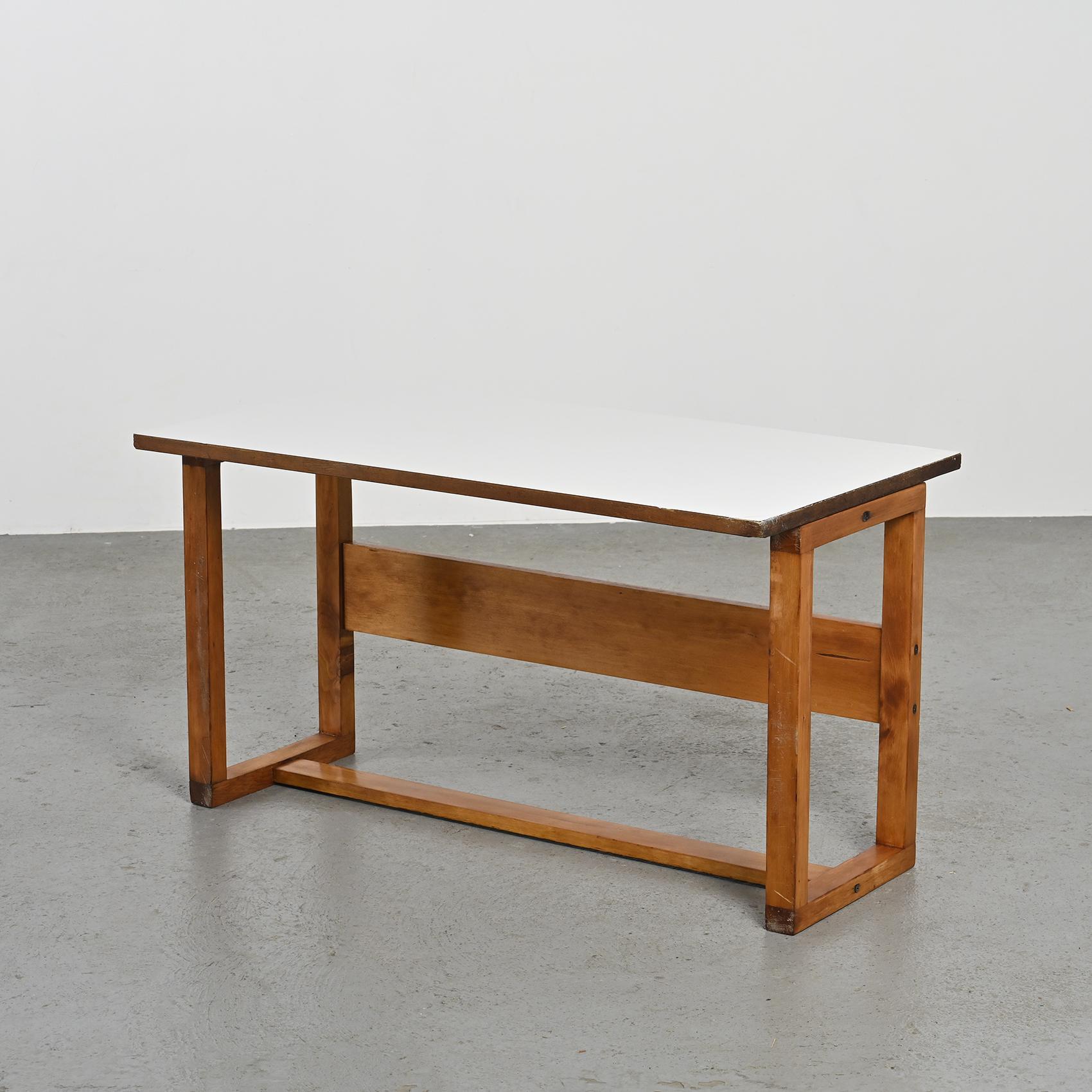 Fabriquée par le visionnaire Pierre Guariche, cette table polyvalente se transforme en table basse, en bureau ou même en table à manger selon vos besoins.

Méticuleusement construit en contreplaqué incurvé et orné d'un stratifié blanc crème, un