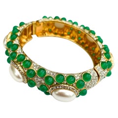 A Moghul-style clear and emerald paste bangle, Kenneth Lane, USA, c1970s.
