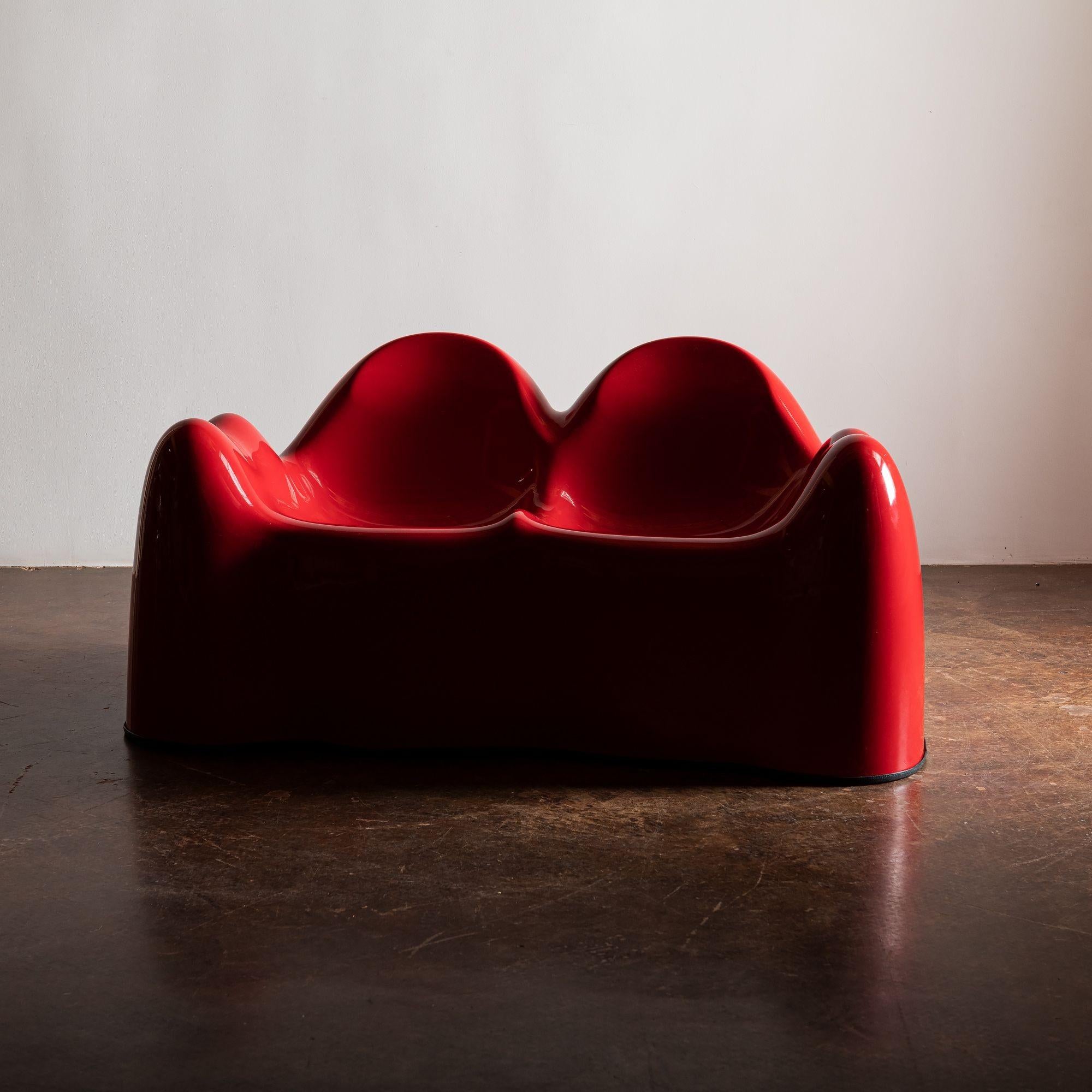 An original Wendall Castle Molar Group settee in red fiberglass with original rubber foot ring, US, 1960s.
