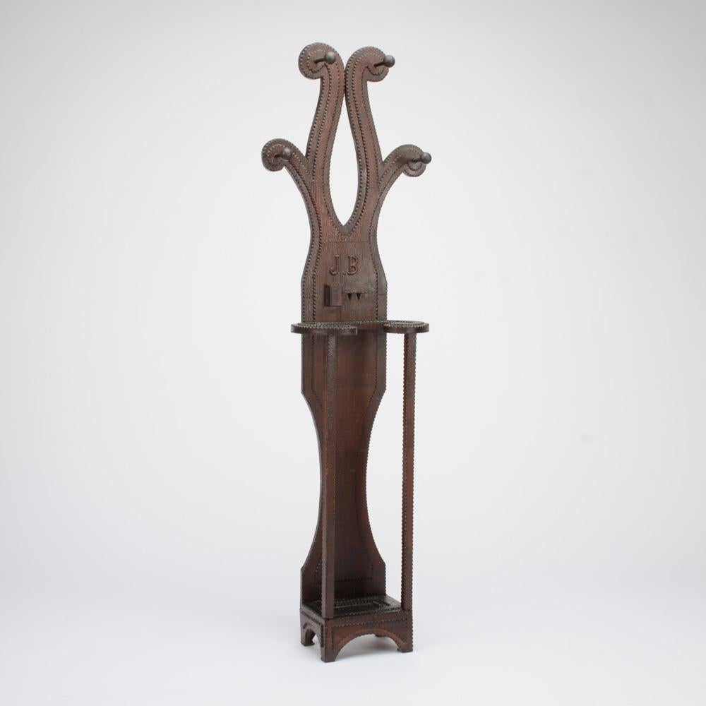 An American 19th century handcrafted Tramp Art hall tree with pipe holder featuring a unique design with J.B. carved initials.