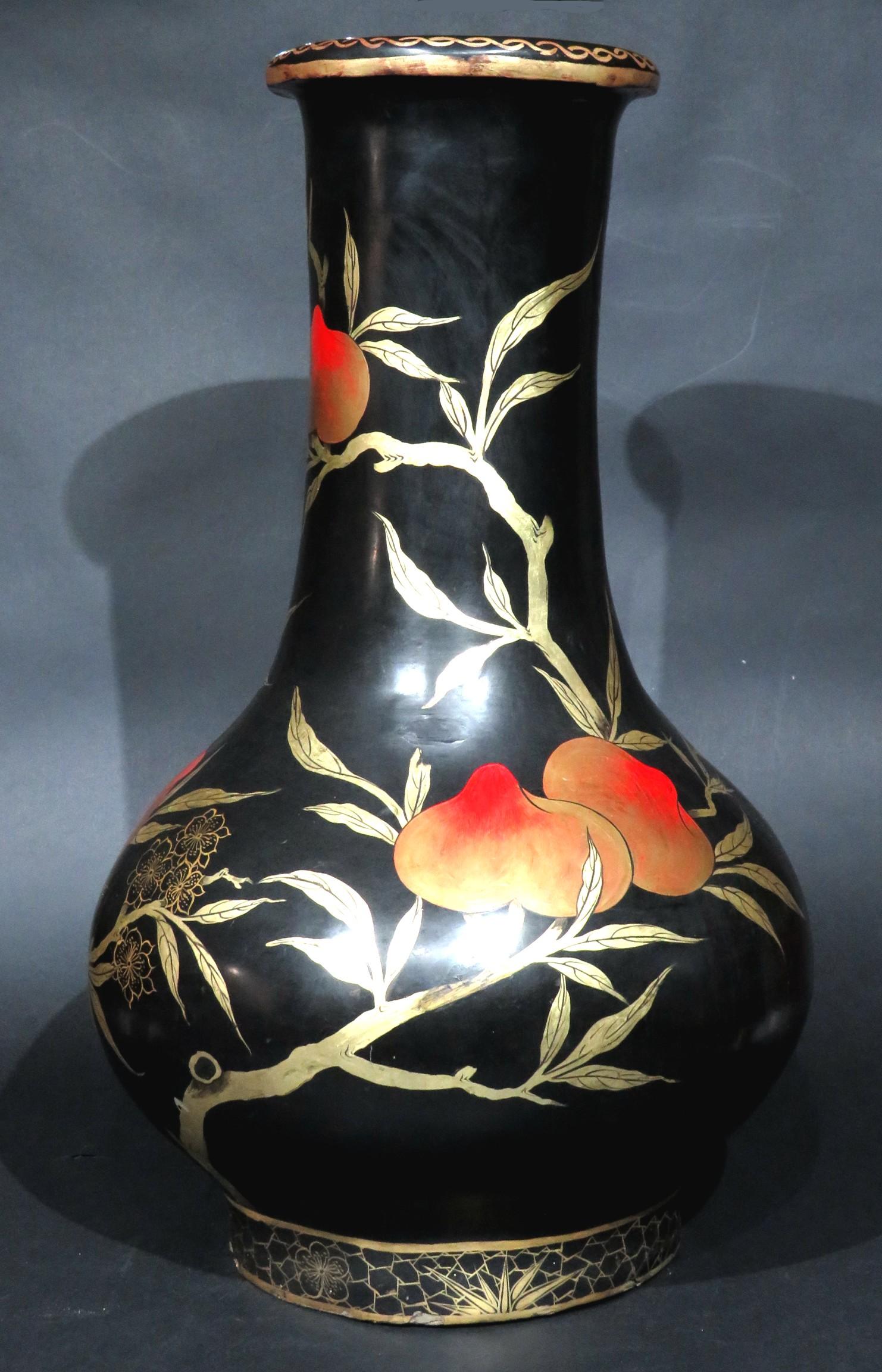 A stunningly attractive & exceptionally large baluster shaped ‘Ryukyu Hariko’ (papier mâché) vase, masterfully decorated overall with hand painted images of a fruiting peach tree rendered in a palette of vermilion, russet & gilt against an ebonized