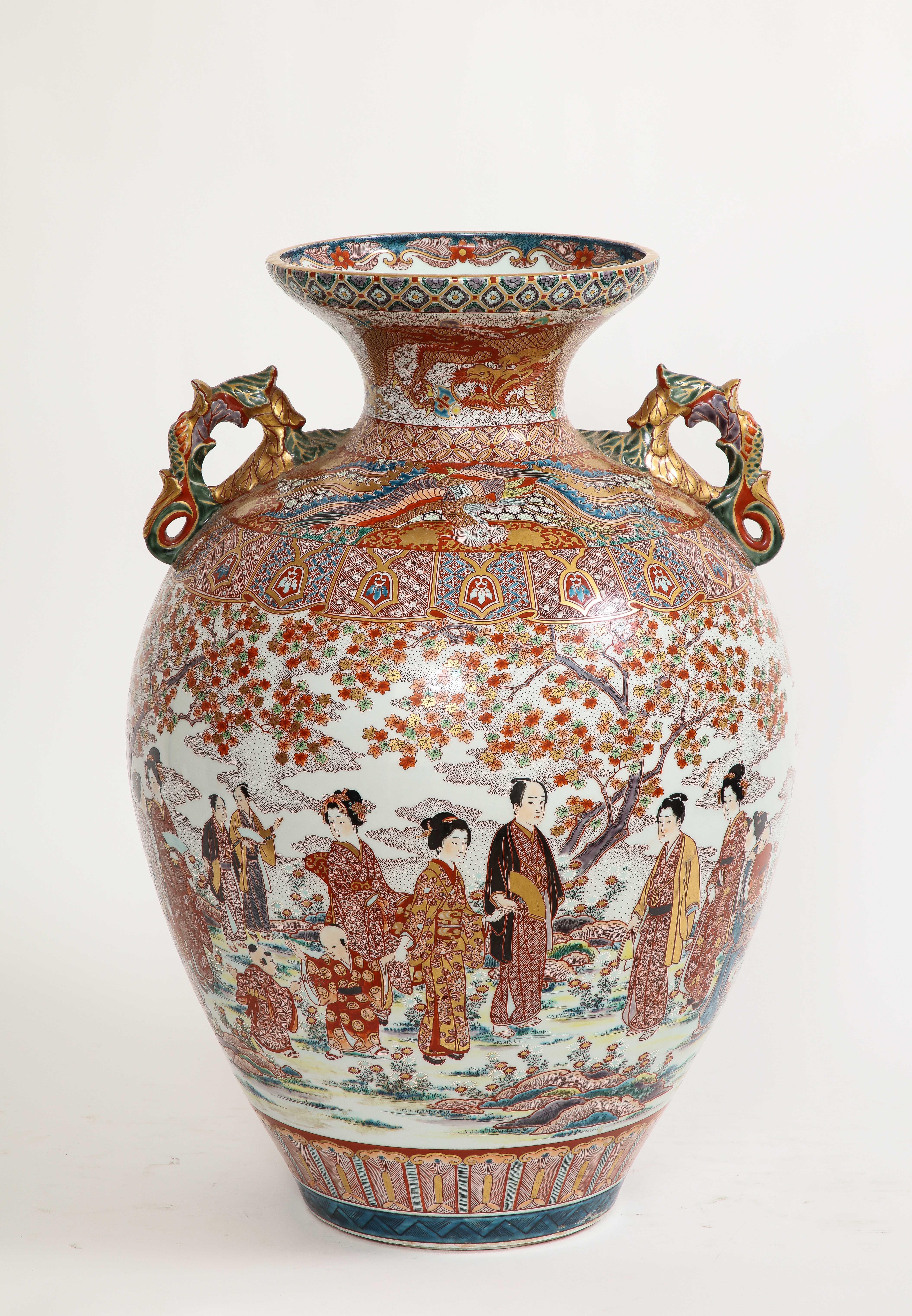 Monumentale japanische Kutani-Porzellanvase, Meiji/Taisho-Zeit, signiert Akiyama sei.  Der Korpus ist komplett handbemalt und mit wunderschönen Dekorationen versehen, darunter japanische Figuren von Jungfrauen, Herren, Blumen, Drachen und Henkel aus