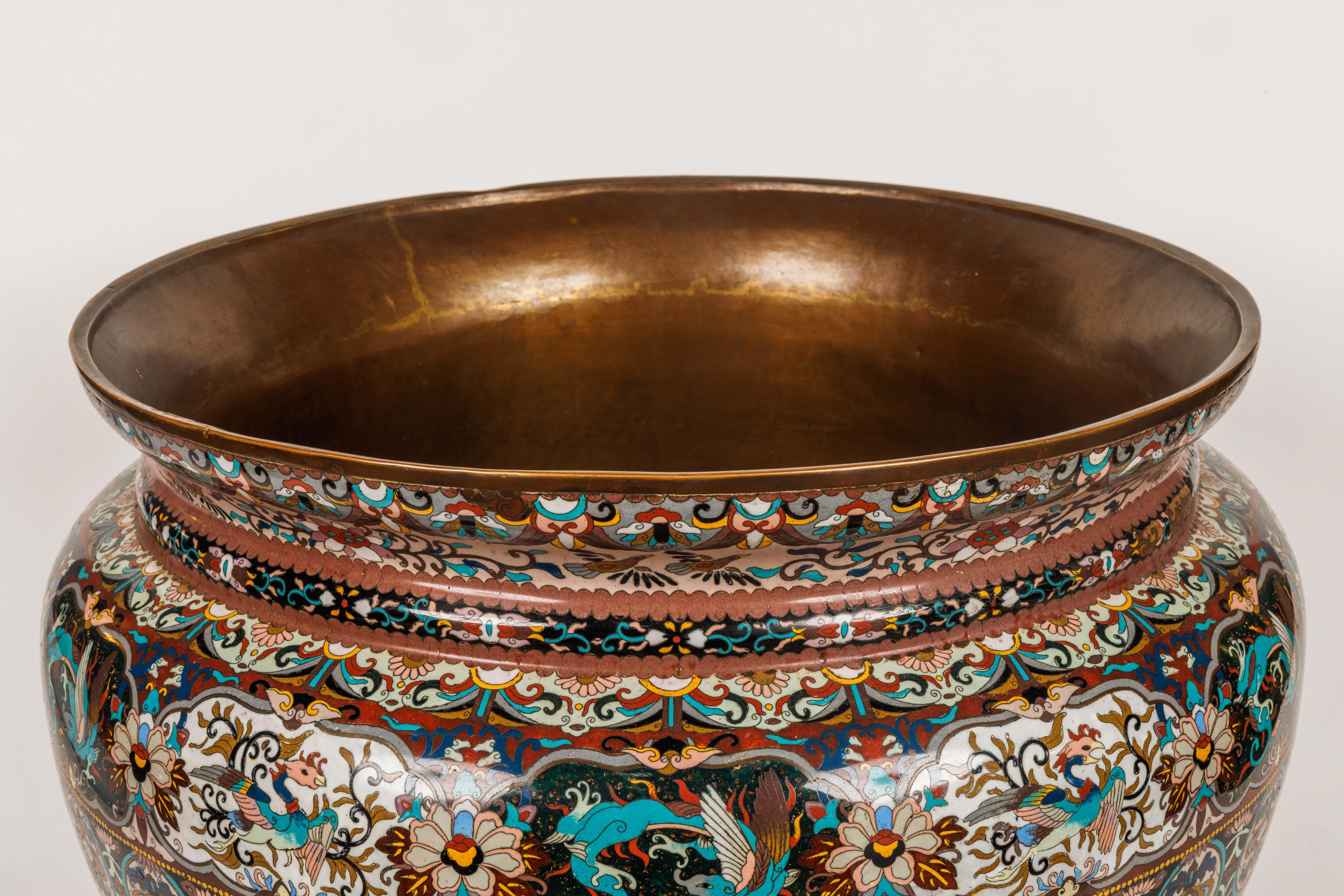 A Monumental Meiji Period Japanese Cloisonne Enamel Jardiniere.

This monumental Meiji Period Japanese cloisonne enamel jardiniere is a magnificent example of the exquisite craftsmanship and artistry that was prevalent in Japan during the late