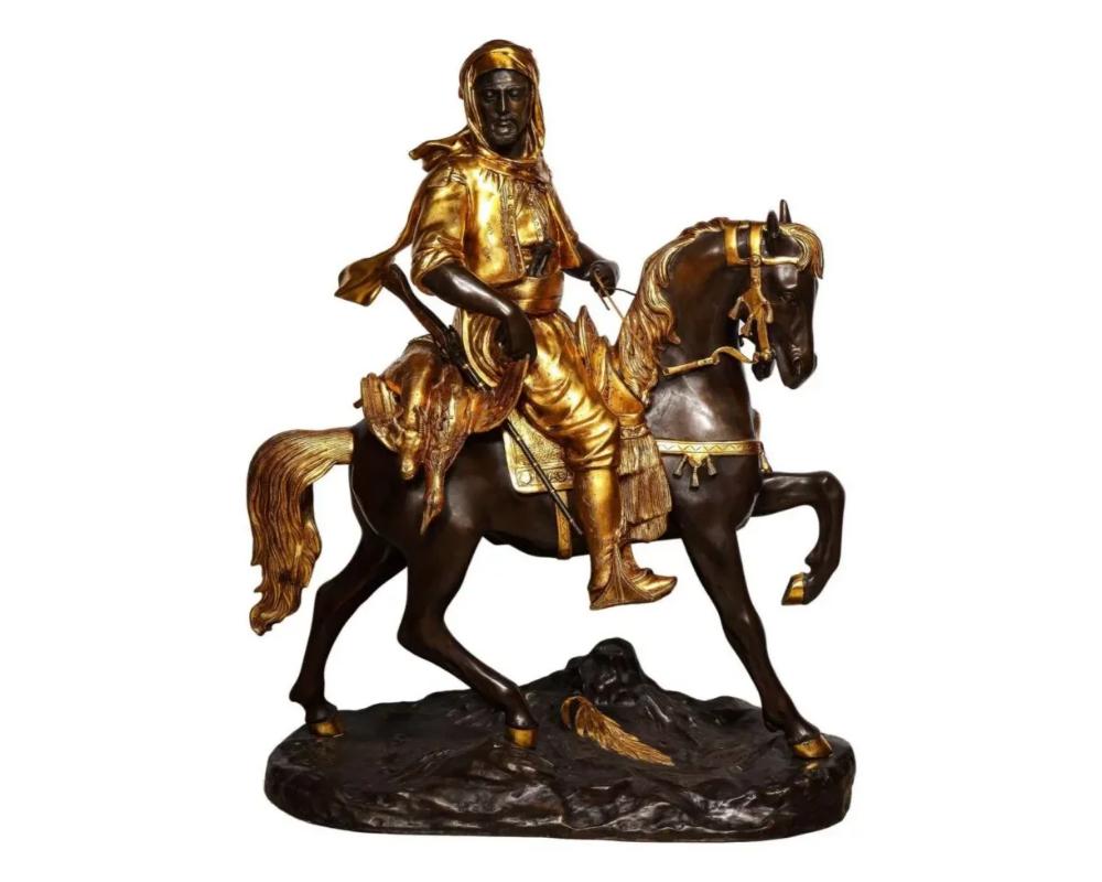 A Monumental Orientalist Bronze Sculpture “Cavalier Arabe” After Emile Guillemin, signed Barge Fils.

This massive sculpture depicts an Arab on a horse returning from his hunt, in gilt and patinated bronze. With gold patina to equestrian figure and