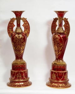 A monumental pair of ruby red gilt Bohemian "Alhambra" cut glass vases on stands