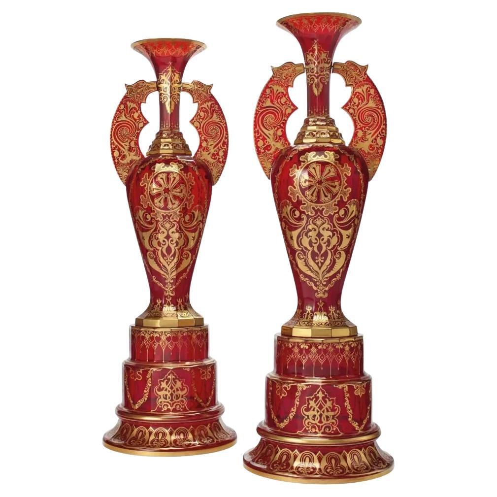 A monumental pair of ruby red gilt Bohemian "Alhambra" cut glass vases on stands For Sale