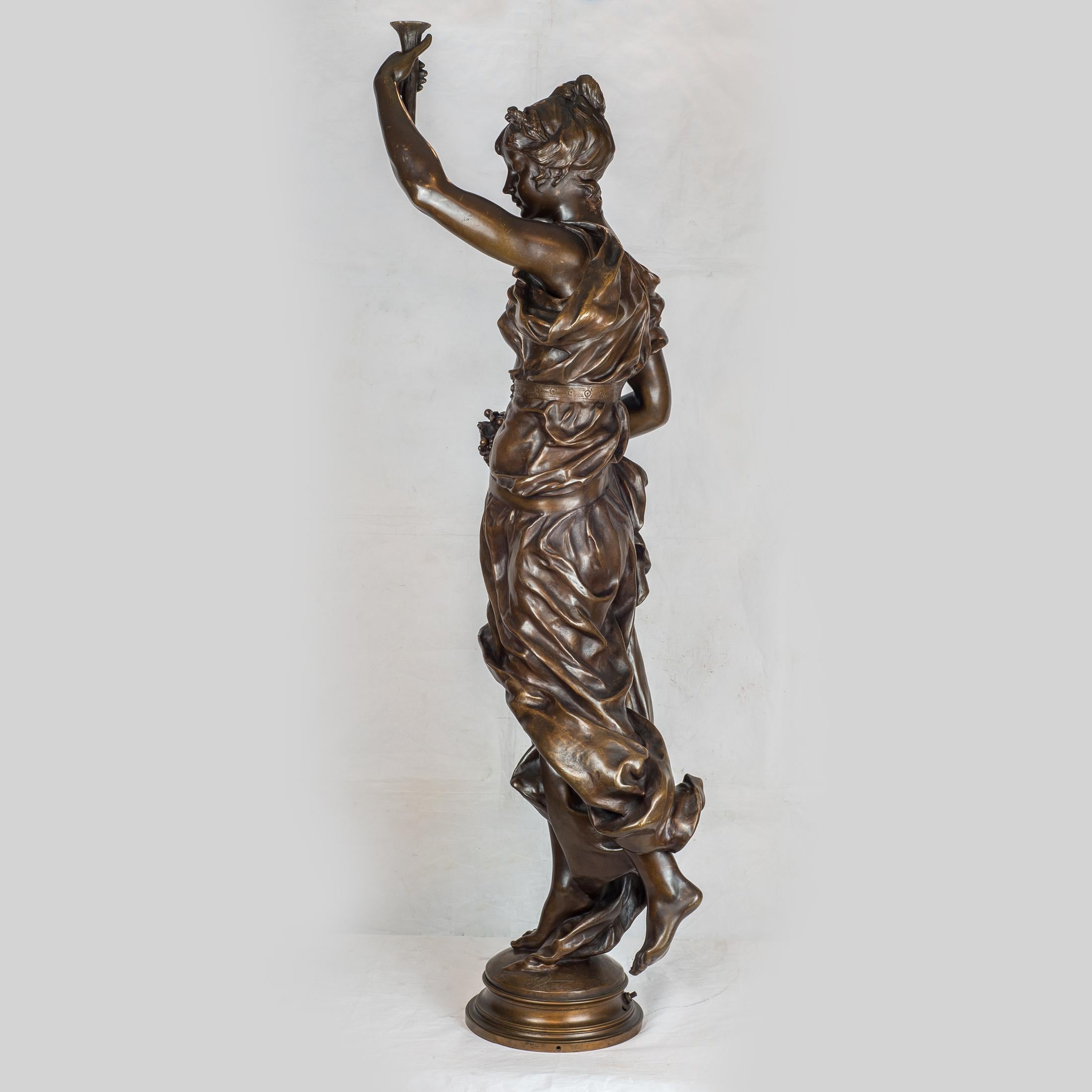 Finely casted patinated bronze figure of a standing young maiden dressed in a classical gown with one hand raised and holding a torch.

Artist: Clément Léopold Steiner (1853-1899)
Origin: French
Date: 19th century
Dimension: 46 1/8 x 22 1/2 x