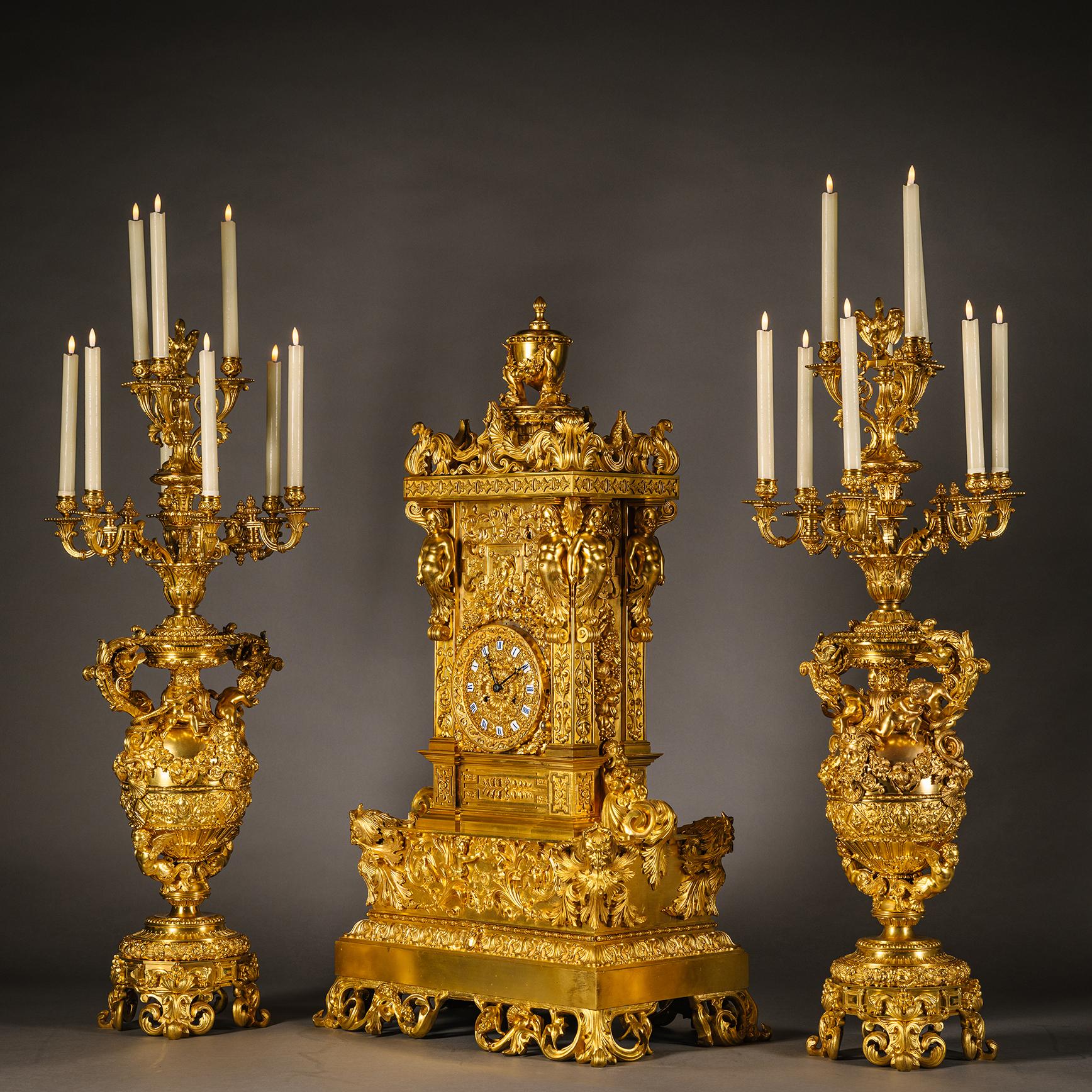 A Large and Important Louis Philippe Period Gilt-Bronze Three-Piece Clock Garniture.

Attributed to the Feuchère family. The clock movement by Hémon.

In the Renaissance revival style. Comprising a clock and a pair of nine-light candelabra. The