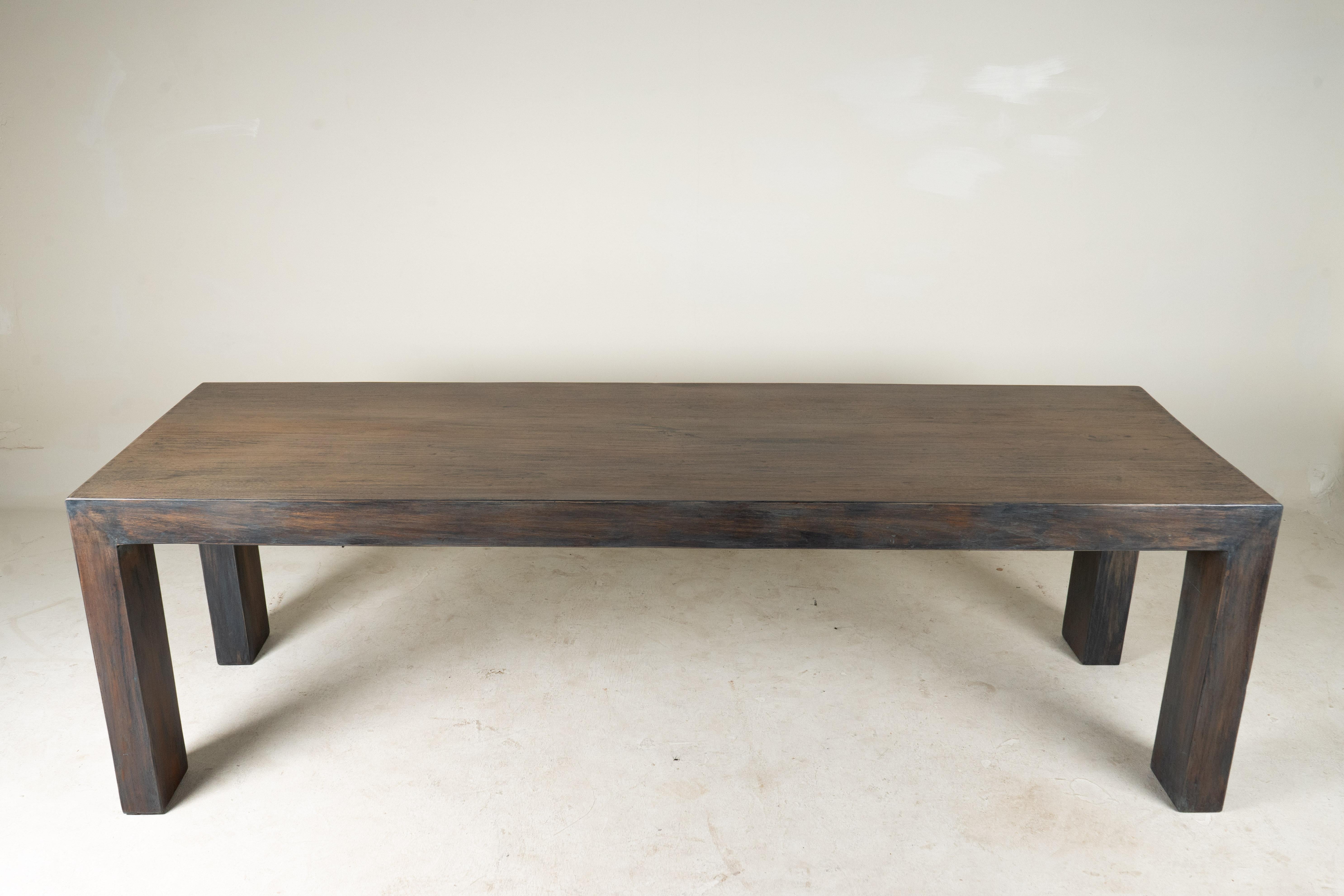 Cette table de salle à manger simple et élégamment angulaire est fabriquée à partir de bois de teck récupéré à Chiang Mai, en Thaïlande. Le design s'inspire des designs modernes des années 1950 que l'on trouve en Birmanie et en Thaïlande, en Asie du