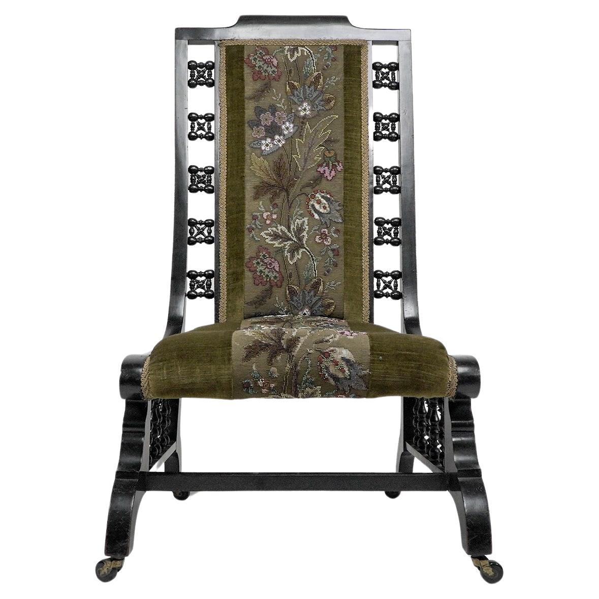 Liberty and Co attributed. A Moorish ebonized parlour chair with Musharabieh turnings to each side of the back and also uniting the seat to the lower stretchers, with extending arched feet. With a beautiful original floral beaded tapestry seat.
