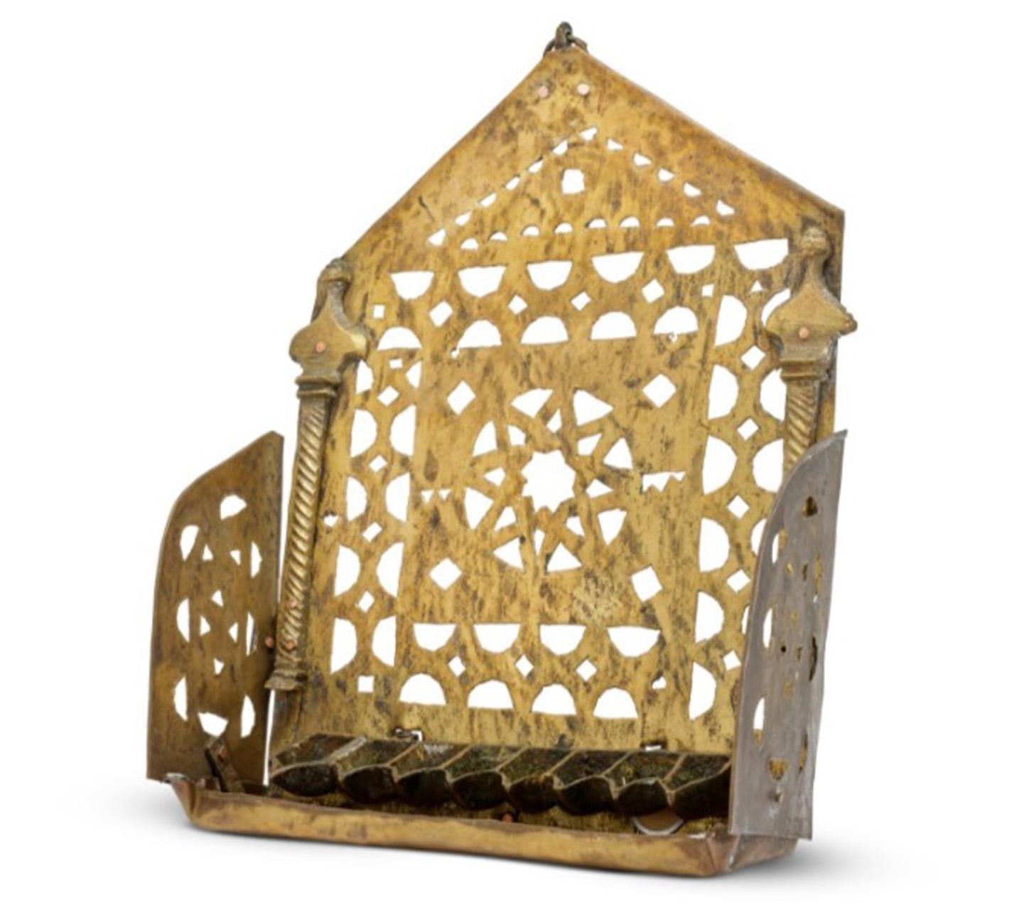 Lampada Hanukkah marocchina in ottone realizzata in Marocco, circa 1900.

Lampada Hanukkah marocchina decorata con colonne e un'autentica Stella di David.

Il piatto posteriore traforato con numerose incisioni a trifoglio e incorniciato da due