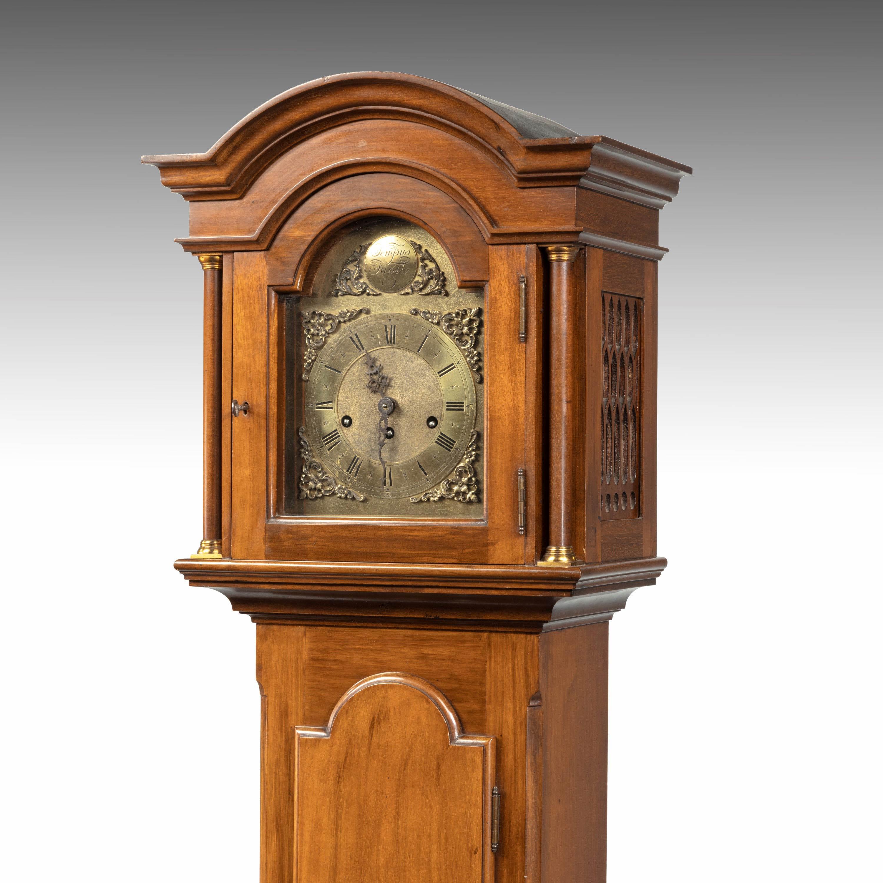 A most attractive early 20the century walnut grandmother clock. With a domed hood above an arched brass dial with both Roman and Arabic numerals. Eight day three train movement chiming on five gongs. Excellent overall condition.
          