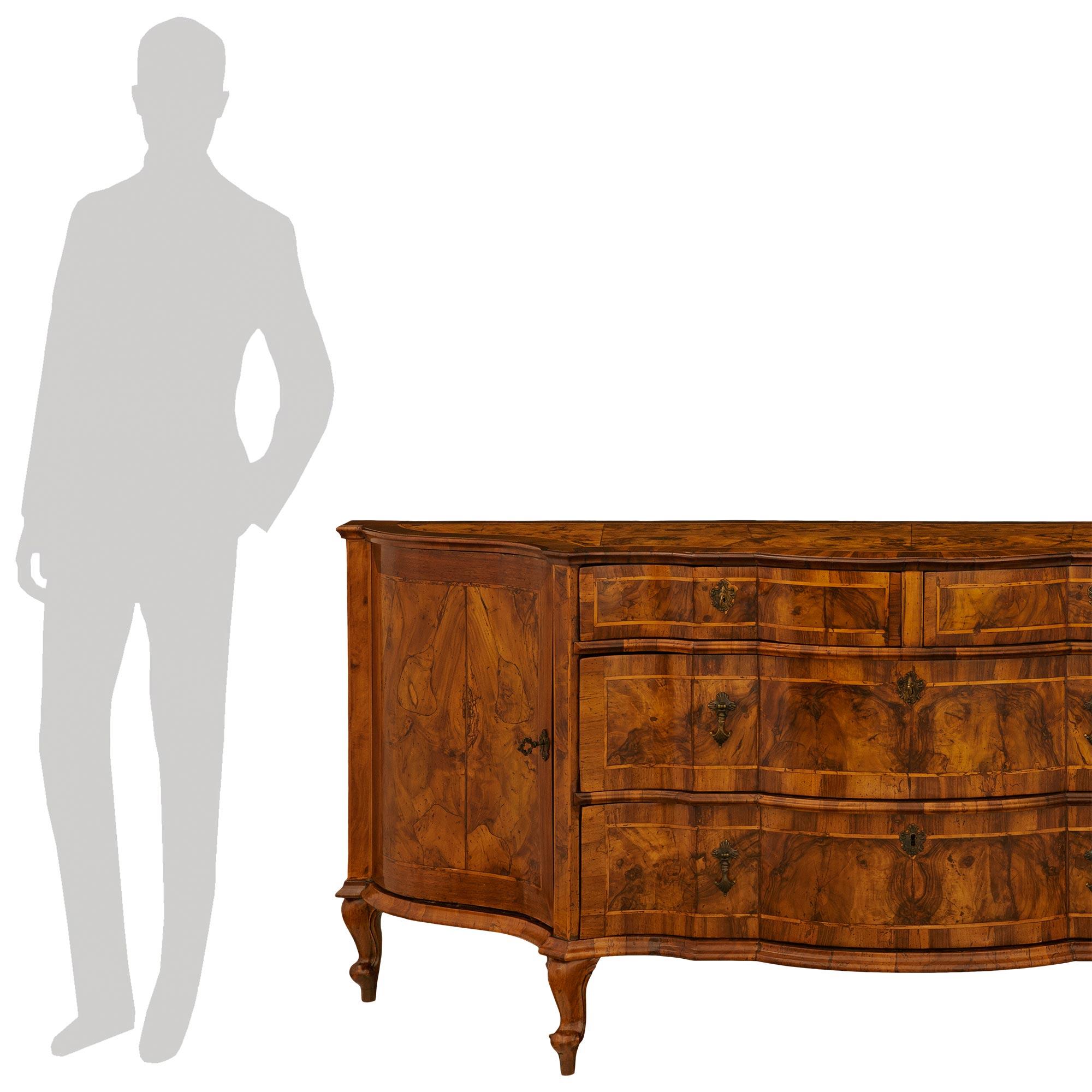 
Un imponente ed elegante buffet veneziano del XVIII secolo in legno di noce e ottone del periodo Luigi XV. Questo buffet di proporzioni sontuose è sollevato da quattro corti piedi cabriole che sostengono il mobile principale composto da quattro