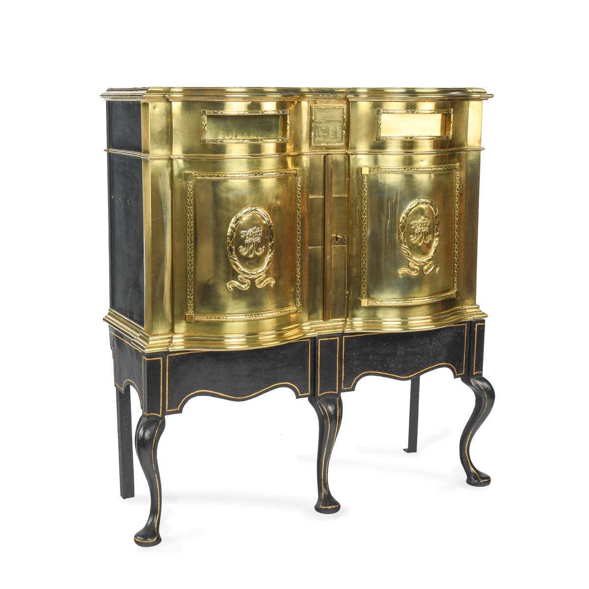 A most unusual Victorian brass private posting box, in the form of a shaped cabinet with two hinged doors, each embellished with a set of initials within a beribboned wreath and with a letter box above, one marked ‘London’ and the other ‘Country’,