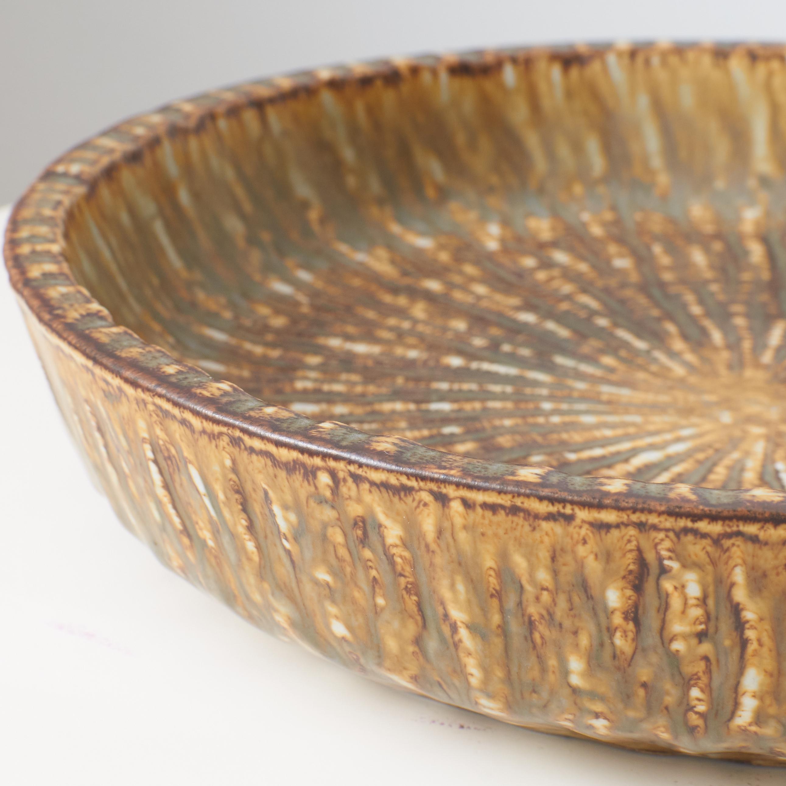 A mottled brown and yellow deep sided round shaped dish by Gunnar Nylund For Sale 1