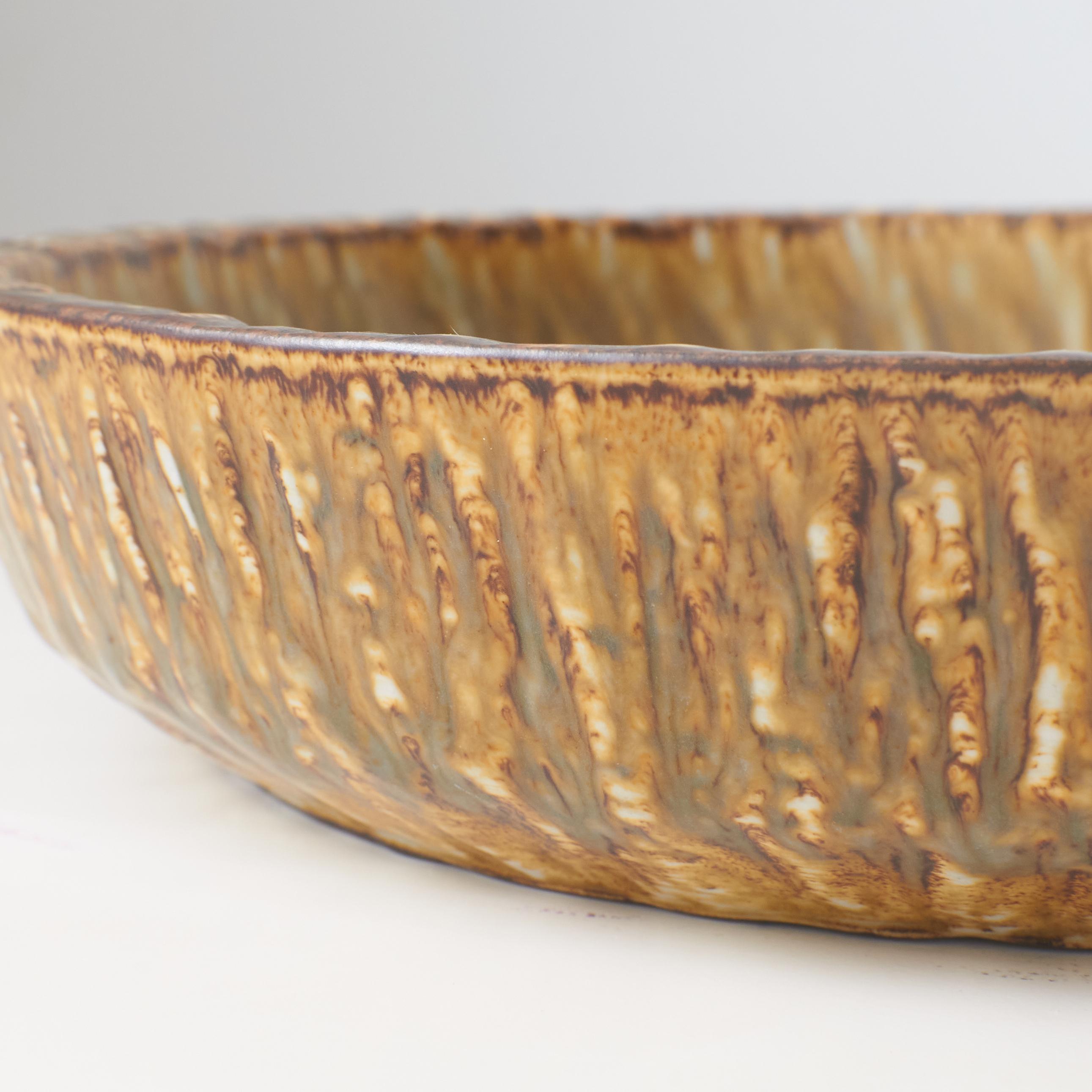 A mottled brown and yellow deep sided round shaped dish by Gunnar Nylund For Sale 2