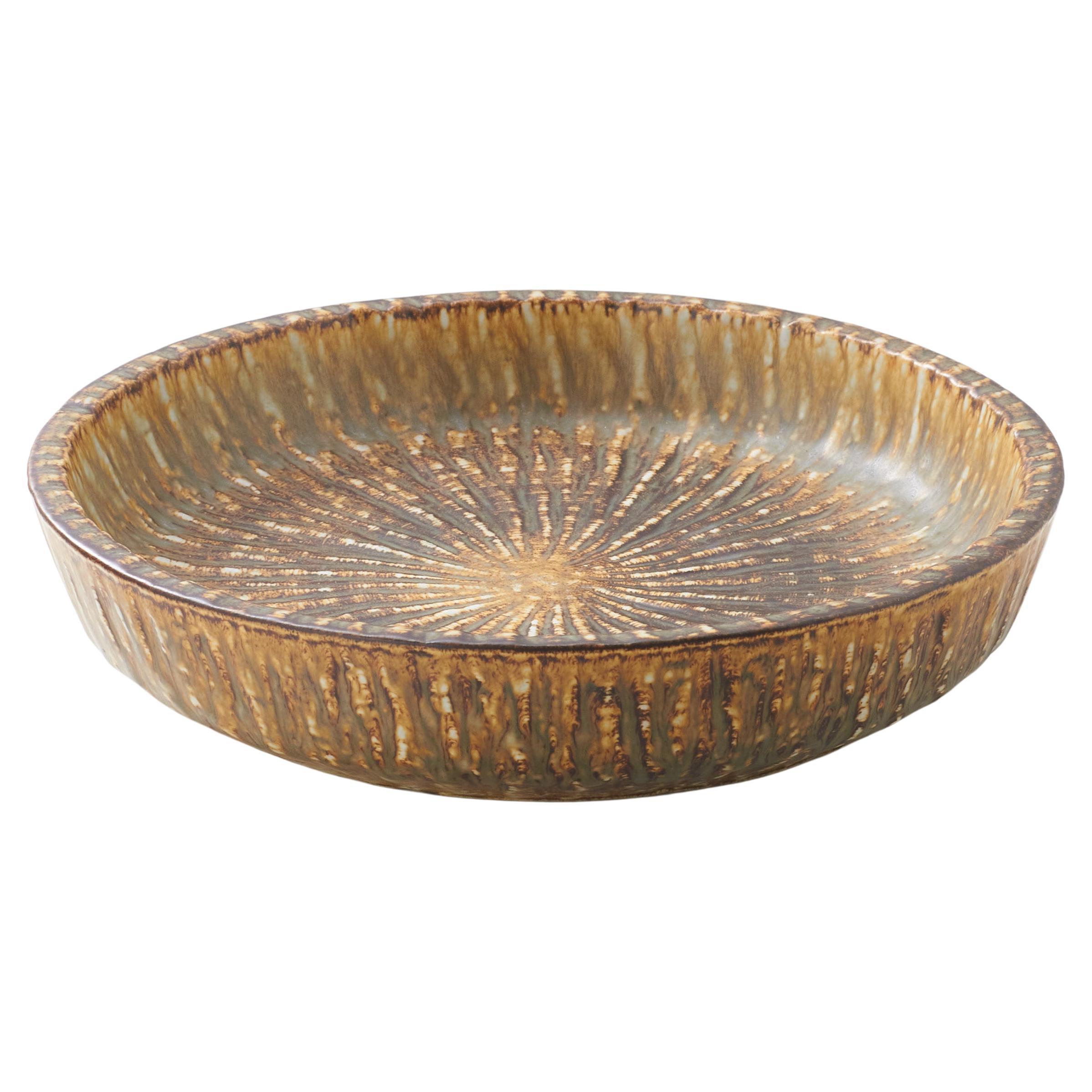 A mottled brown and yellow deep sided round shaped dish by Gunnar Nylund For Sale