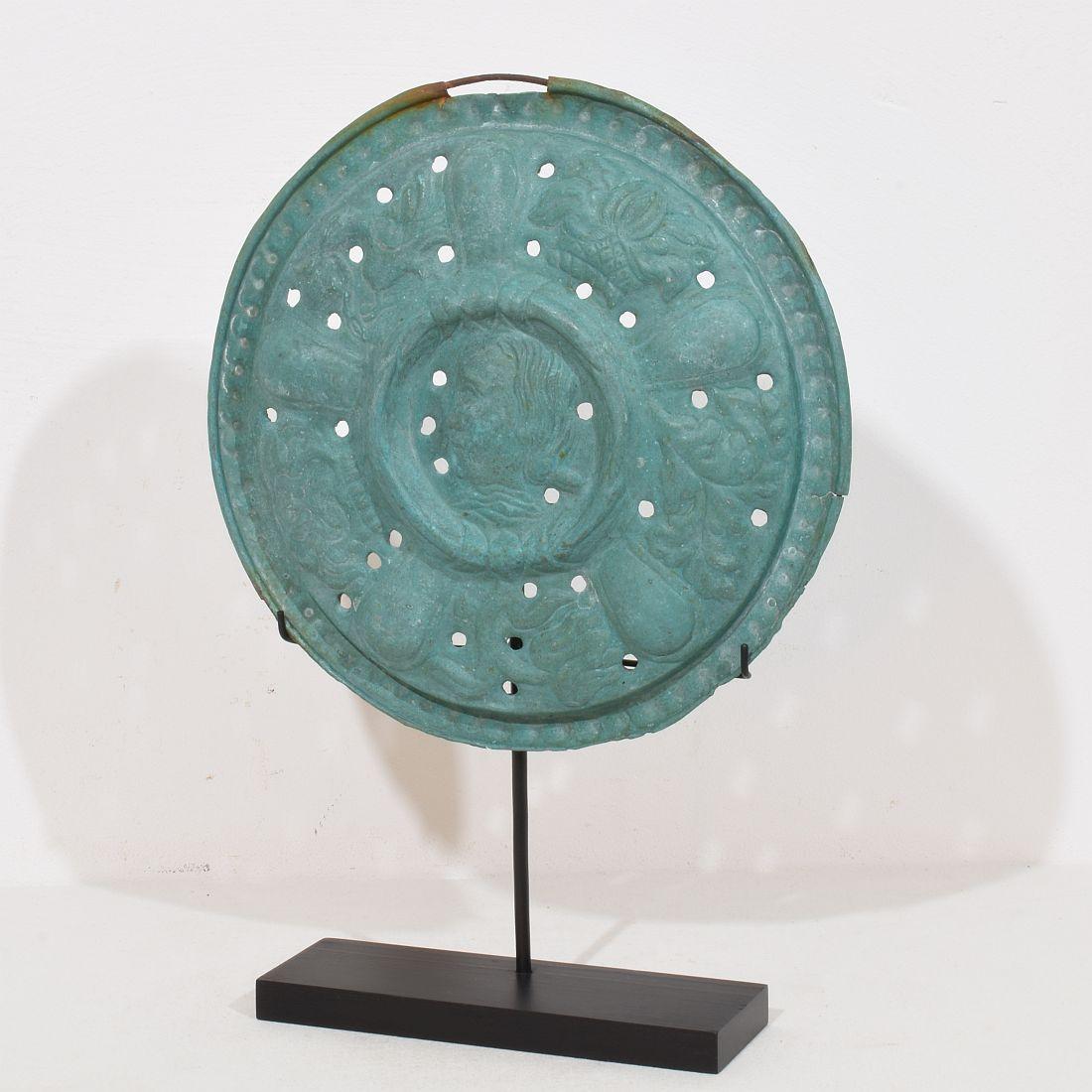 Este  Elemento decorativo de latón perforado procedente de Francia, originalmente era la tapa de un bassinoire de la década de 1600. Un bajorrelieve es un dispositivo en el que se introducen brasas calientes en un receptáculo ventilado que se pasa