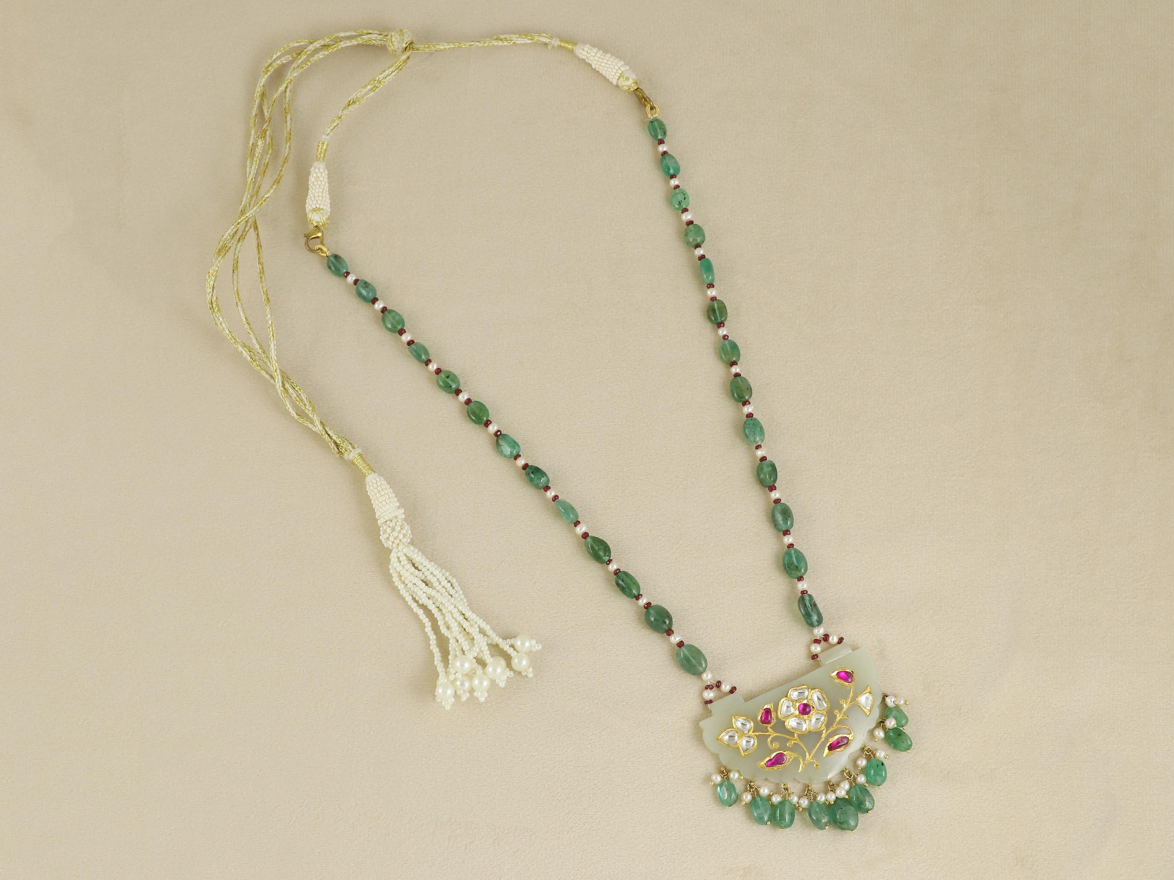 Questo ciondolo, un suggestivo tributo al lusso Mughal, è realizzato in preziosa giada nefrite bianca di montone, apprezzata per la sua morbida traslucenza e la lucentezza vellutata. La parte anteriore mostra un bellissimo amuleto intagliato,